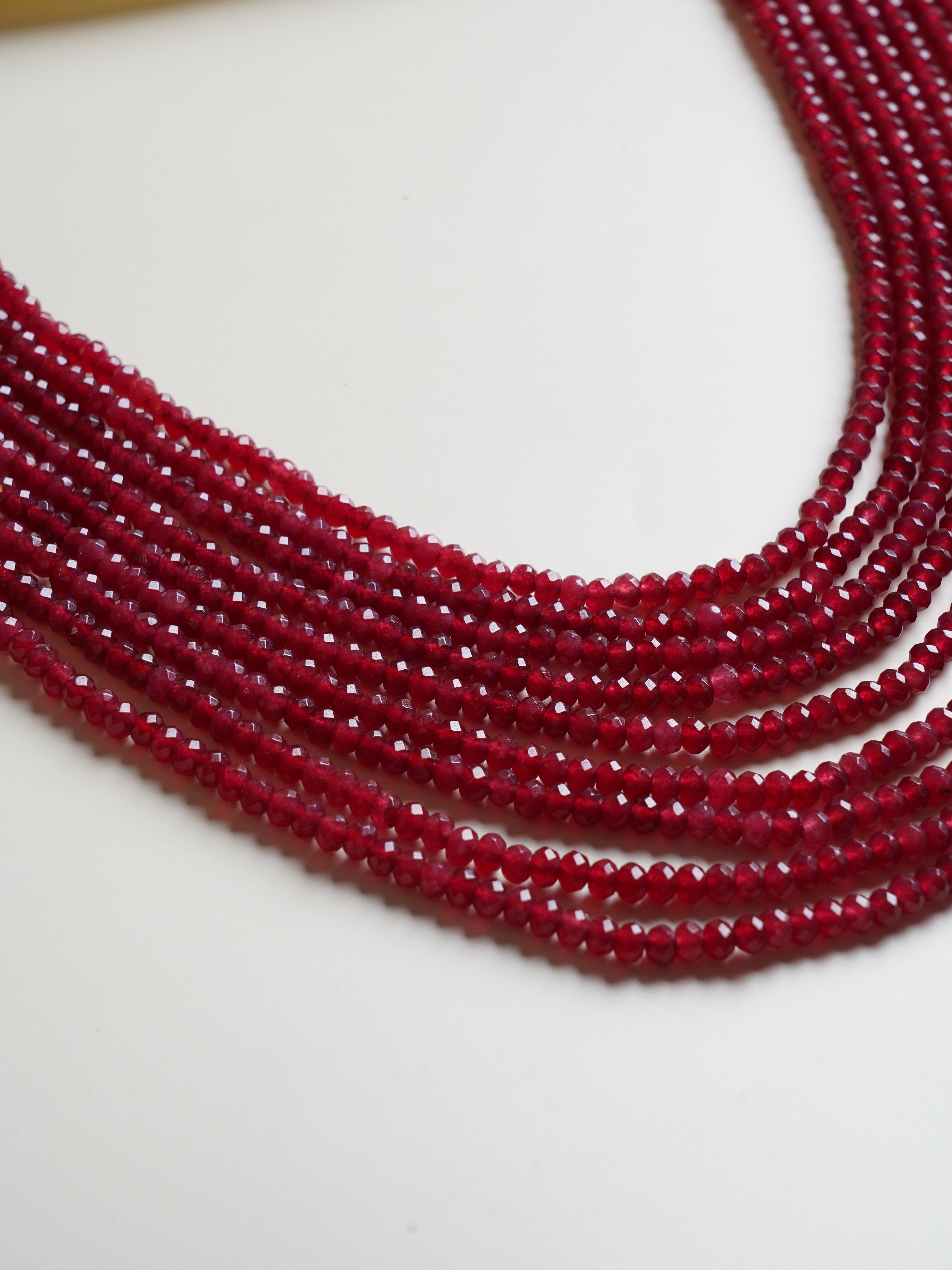 Angled display of beaded necklace showing sparkle and blend of rich jewel tones