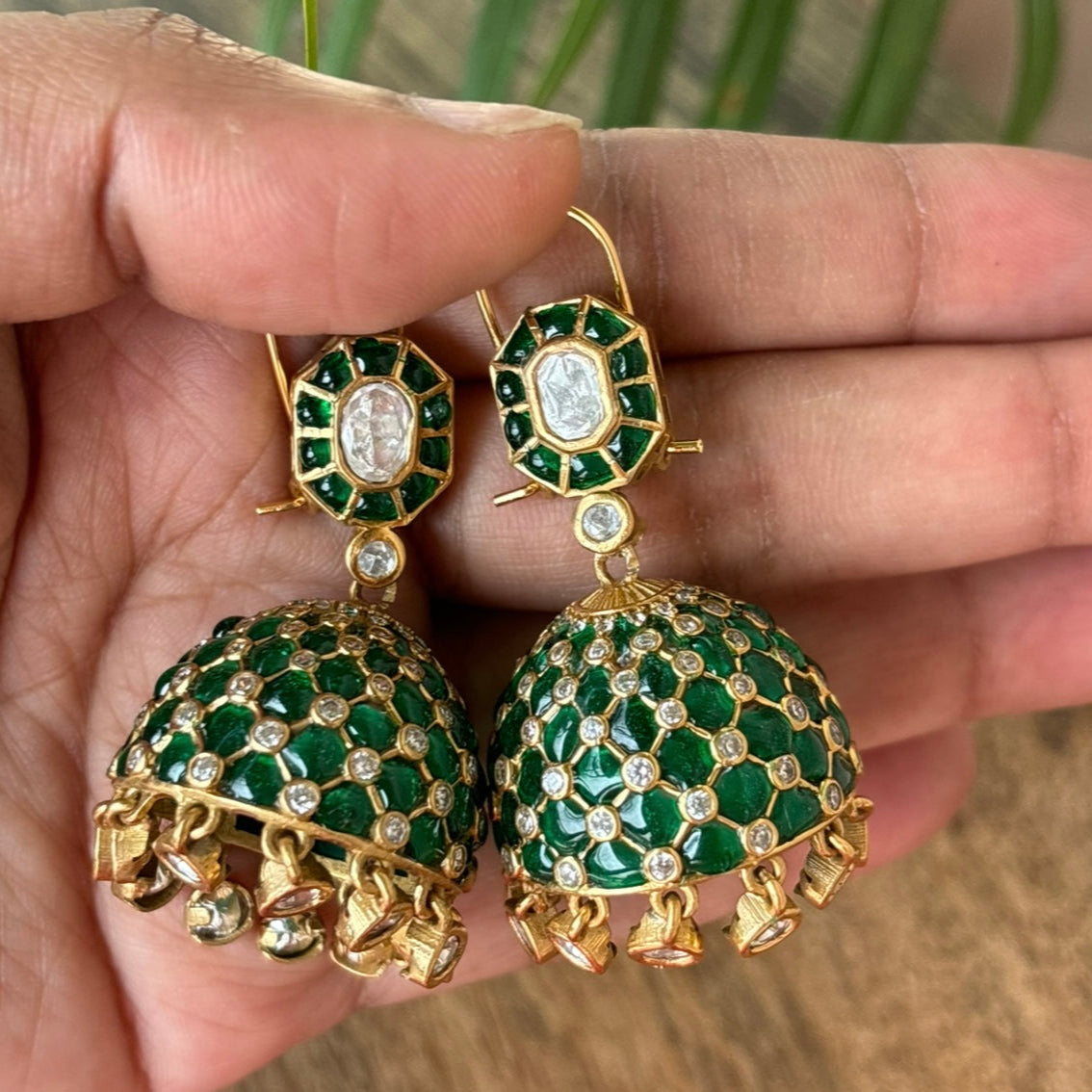 Top angle showing intricate design of gold-toned jhumkas with turquoise accents