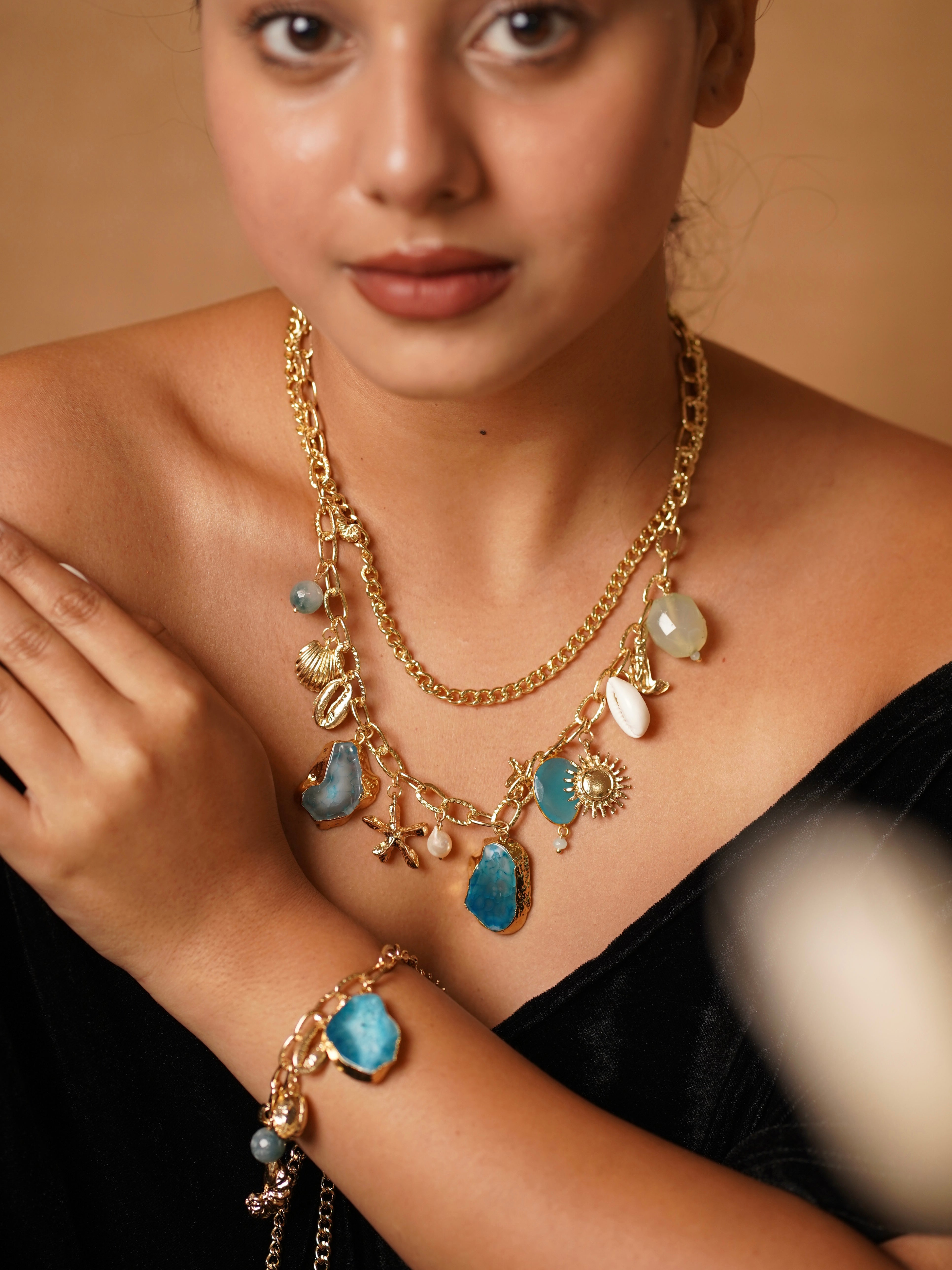 Blue enamel charm necklace set with seashell motifs and gold-toned accents