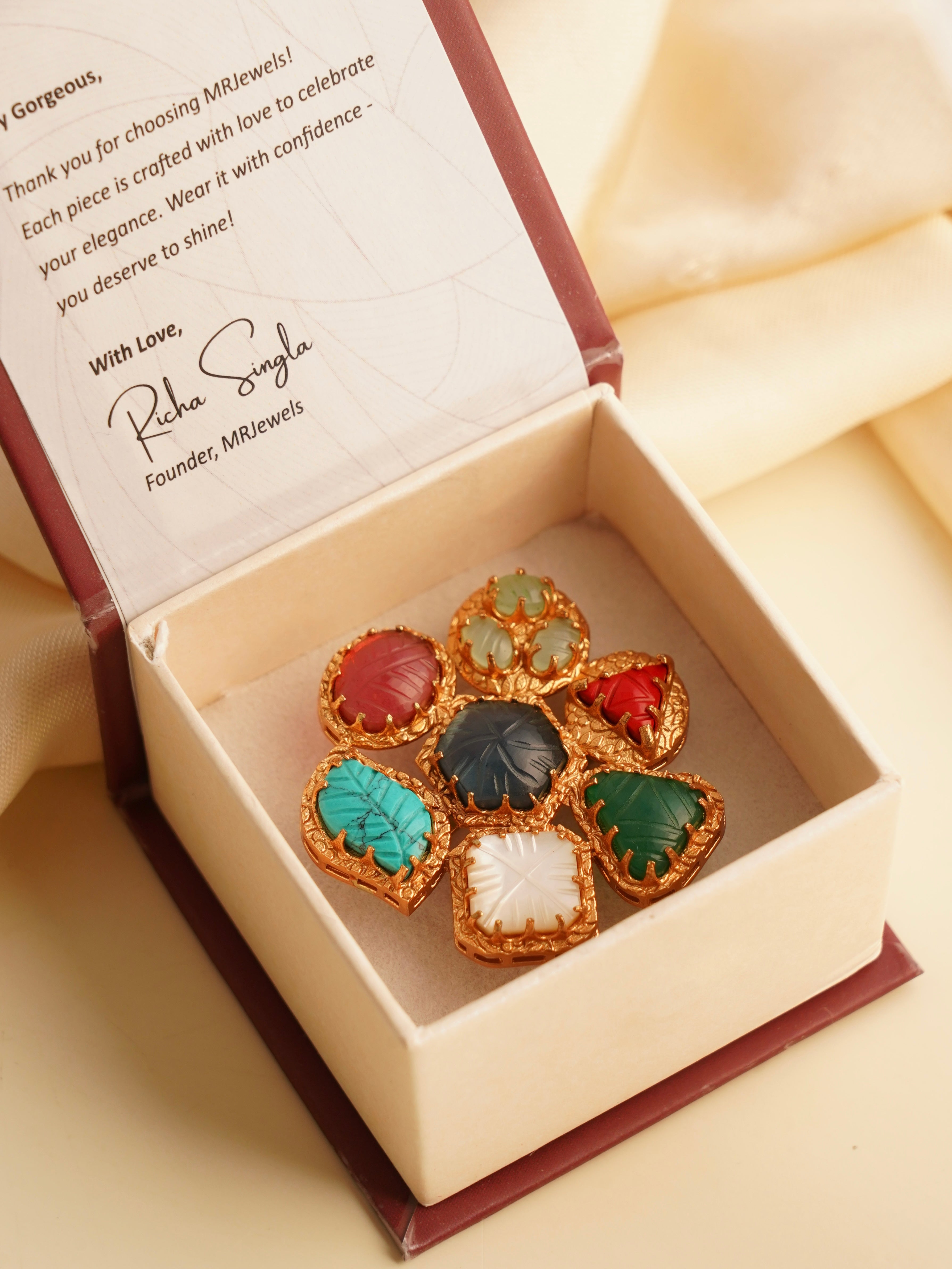 Side angle of navratna earrings showing raised carving and gold border