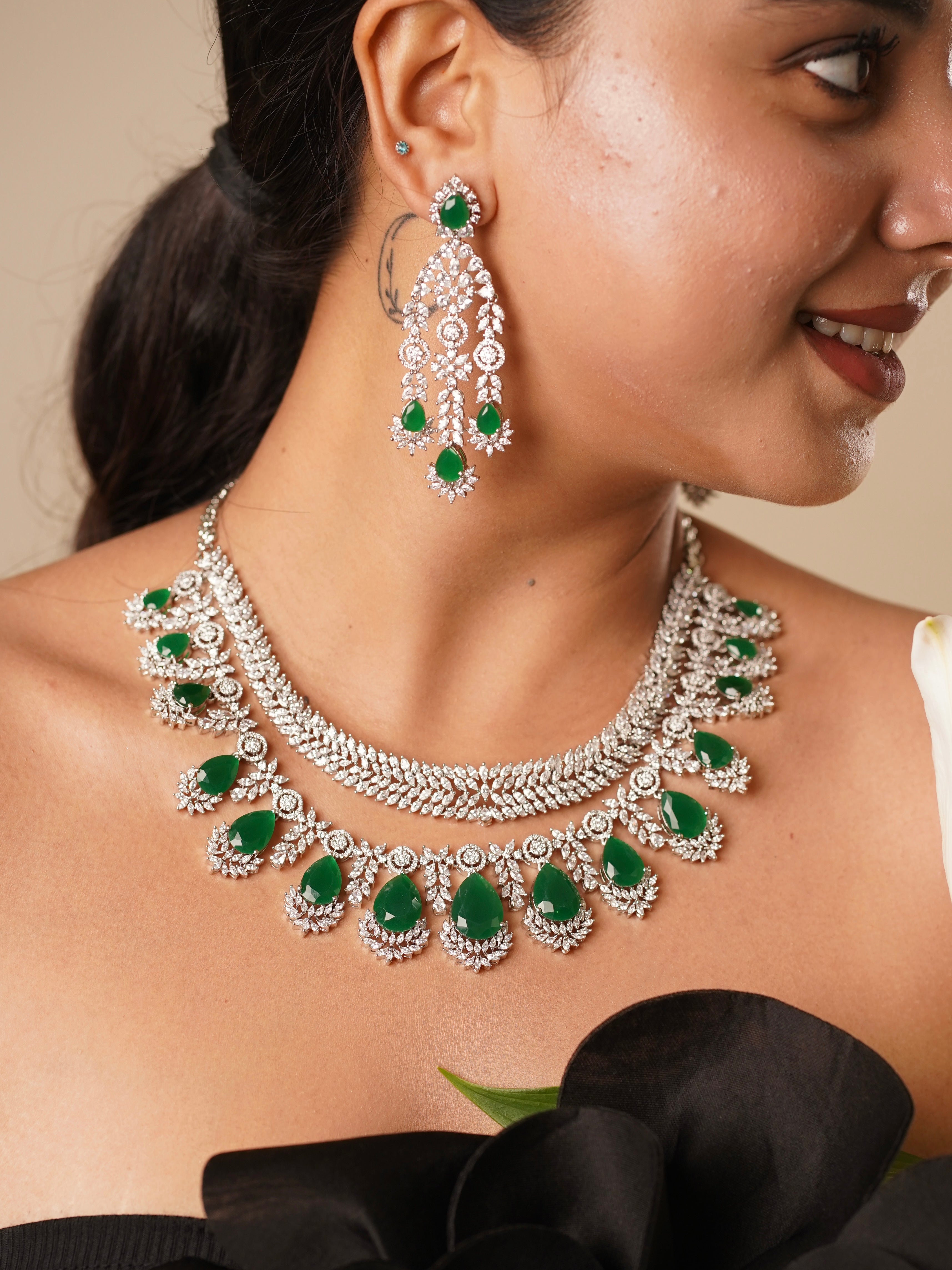 Side view of emerald cocktail necklace with matching 7 cm earrings and shimmering detail