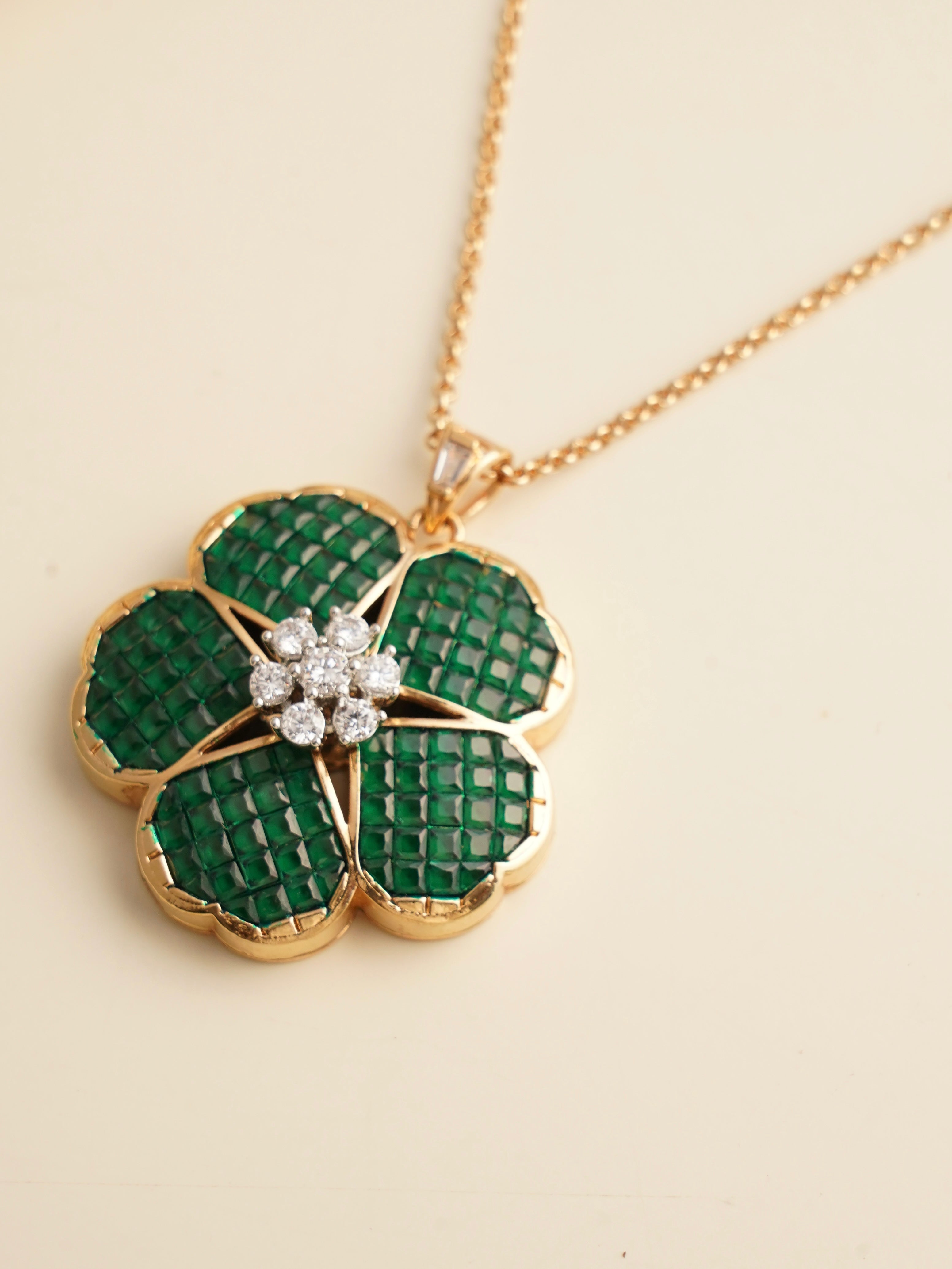 Earring close-up from emerald pendant set with green enamel and gold plating