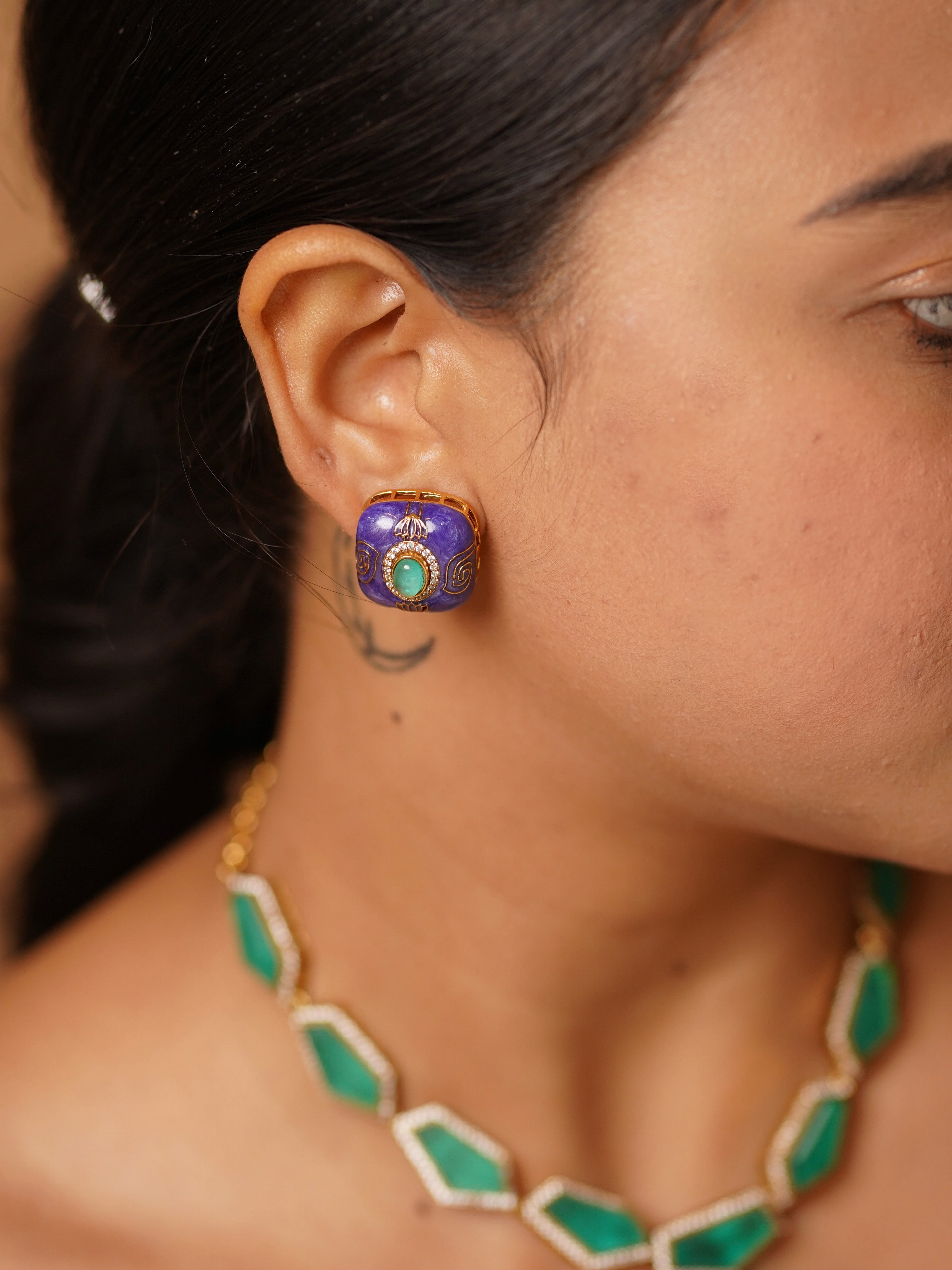 Back view of pendant set showing meenakari detailing and central green gemstone