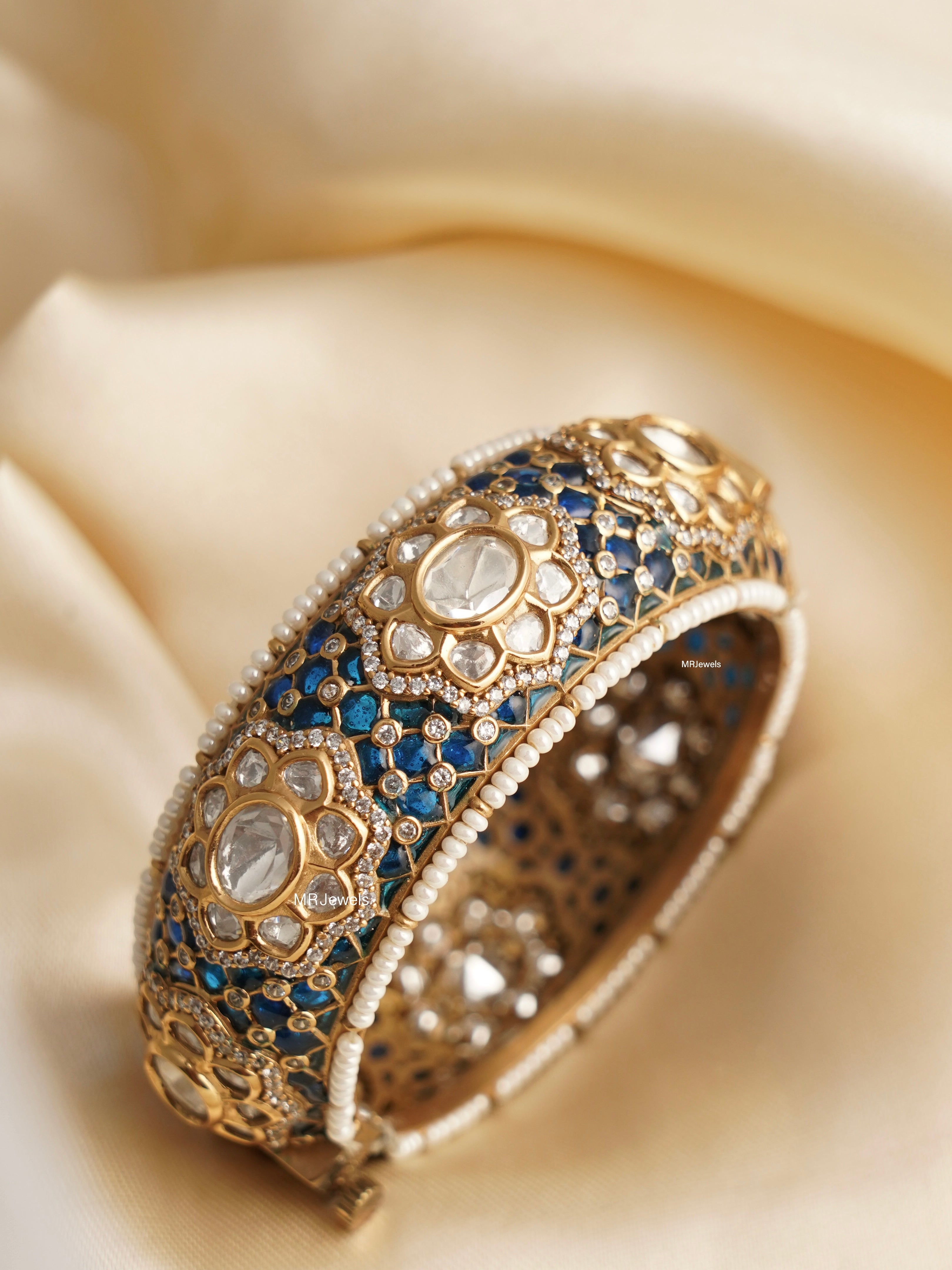 close-up of gold-finished kundan polki kada with vibrant meenakari detailing