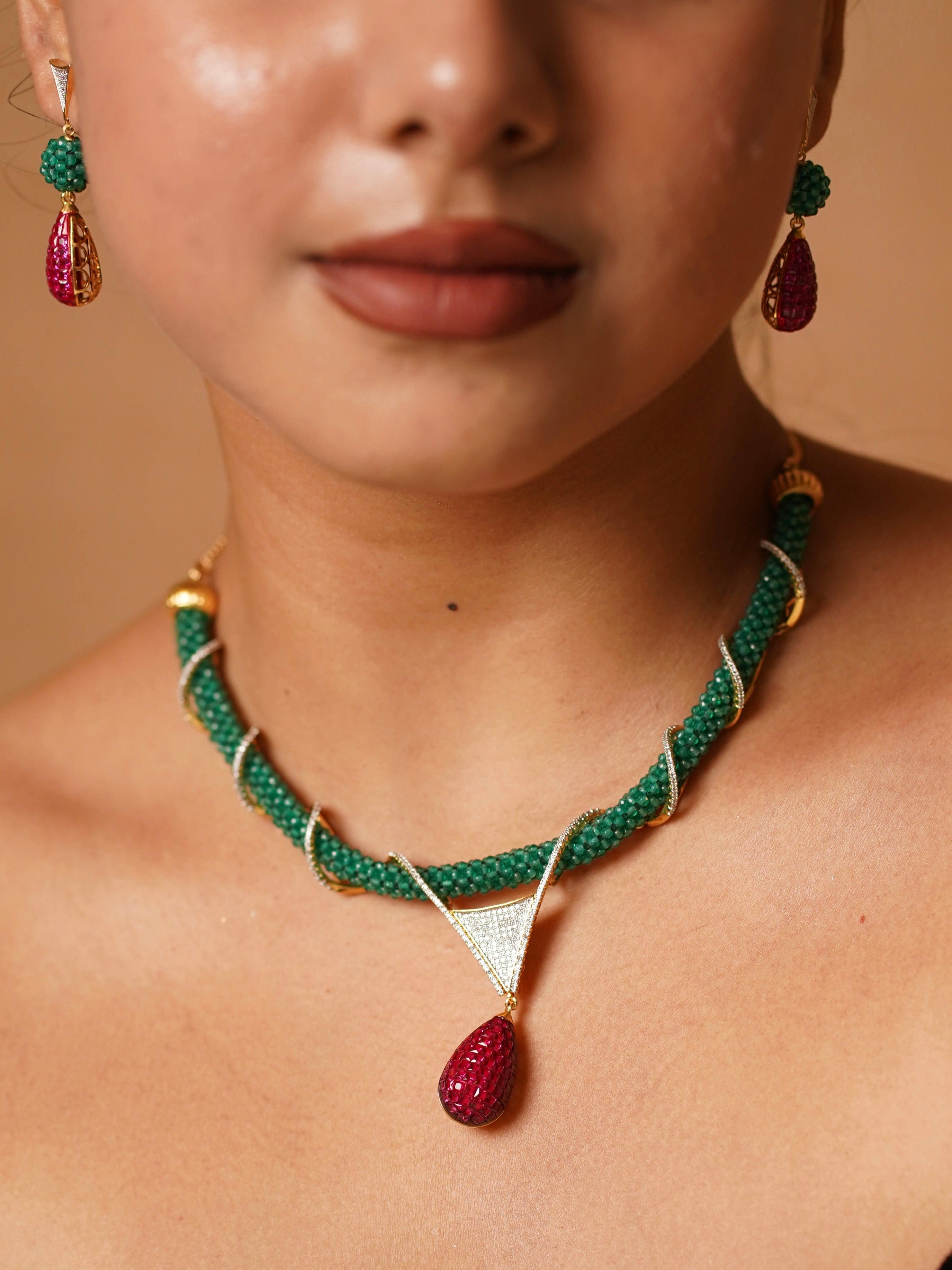 Emerald and ruby hasli set with green thread braiding and bold red pendant centerpiece