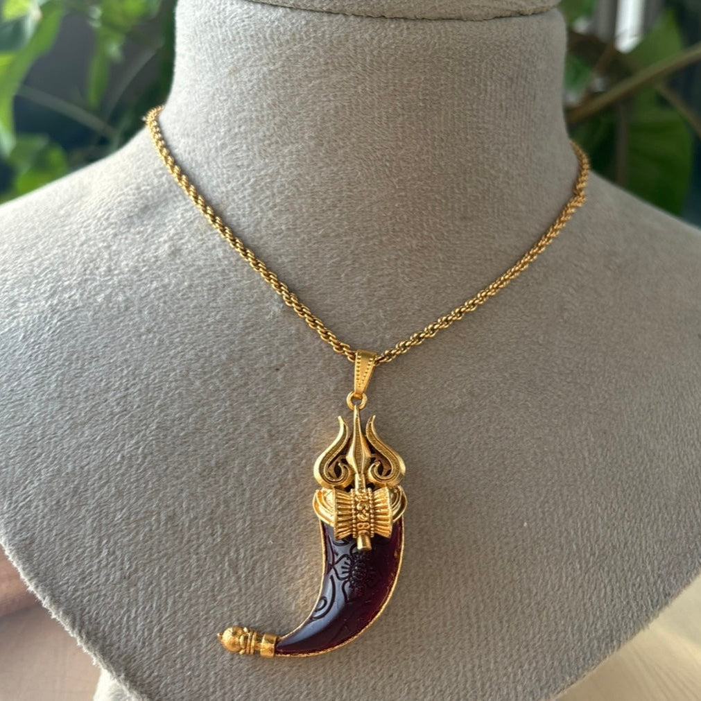 Close-up of trident-shaped pendant with semi-precious stone on gold finish