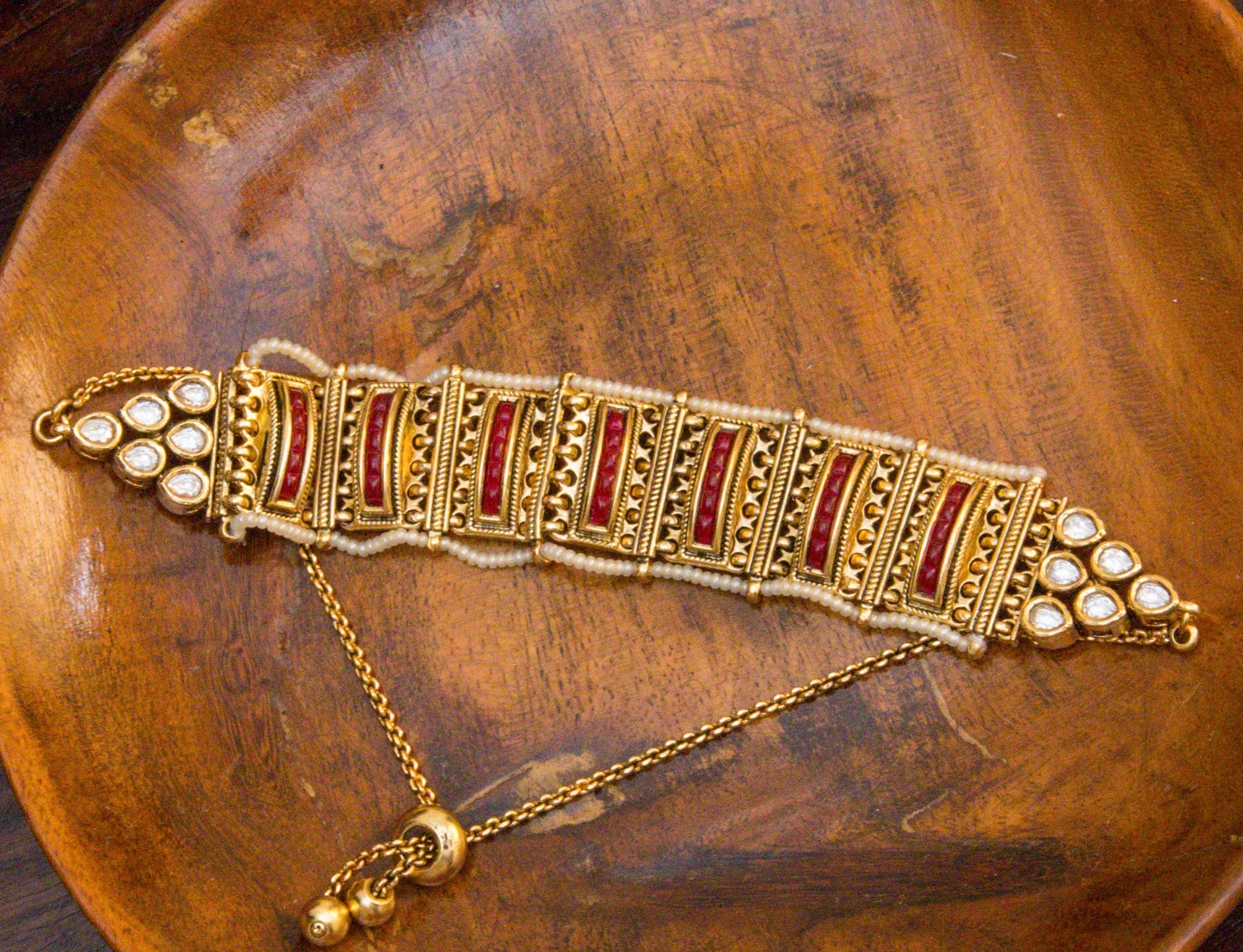 Gold-plated ruby bracelet with kundan work, pearls, and matte antique polish