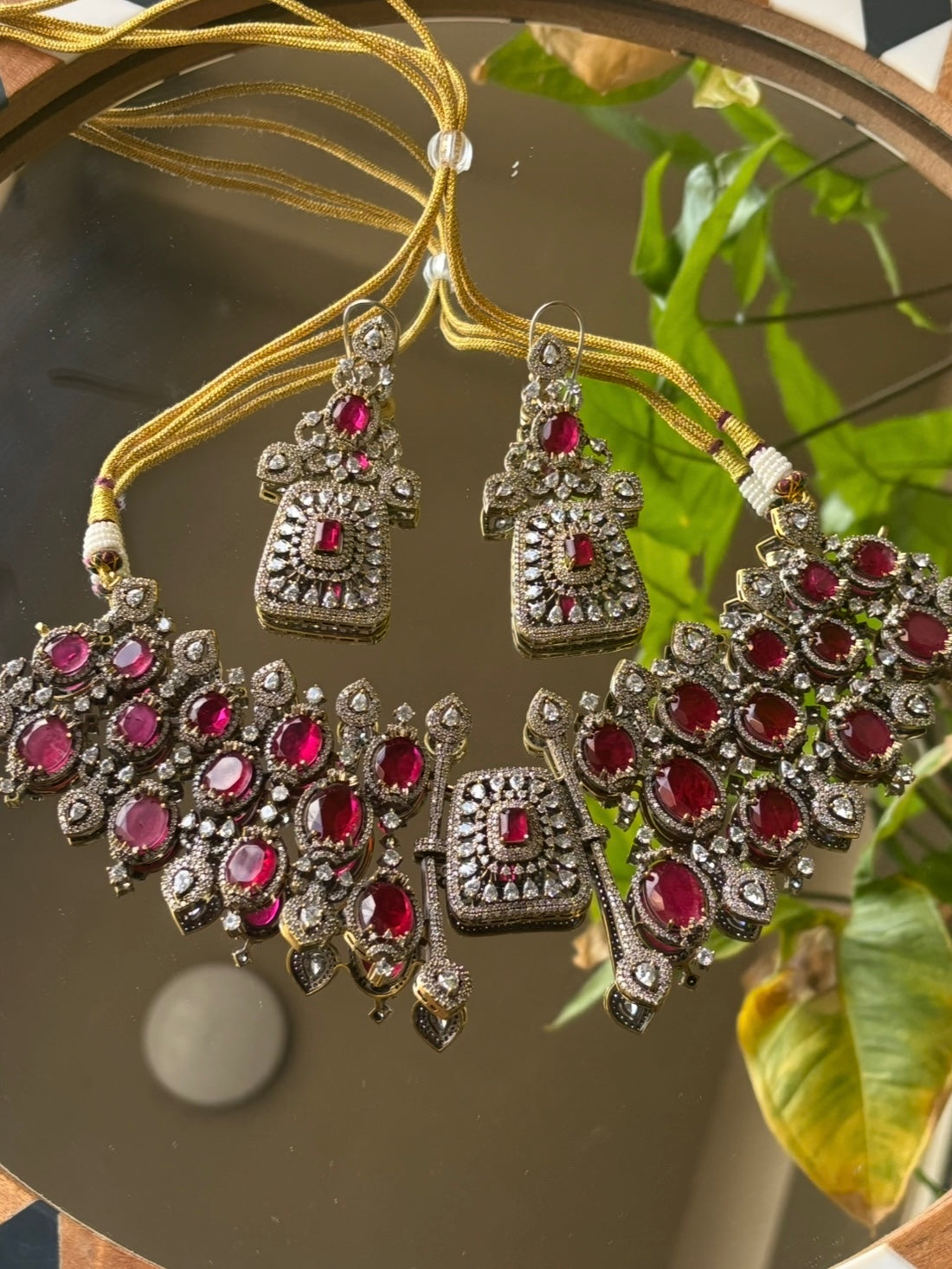 Close-up of emerald and ruby statement necklace with layered design and handcrafted texture