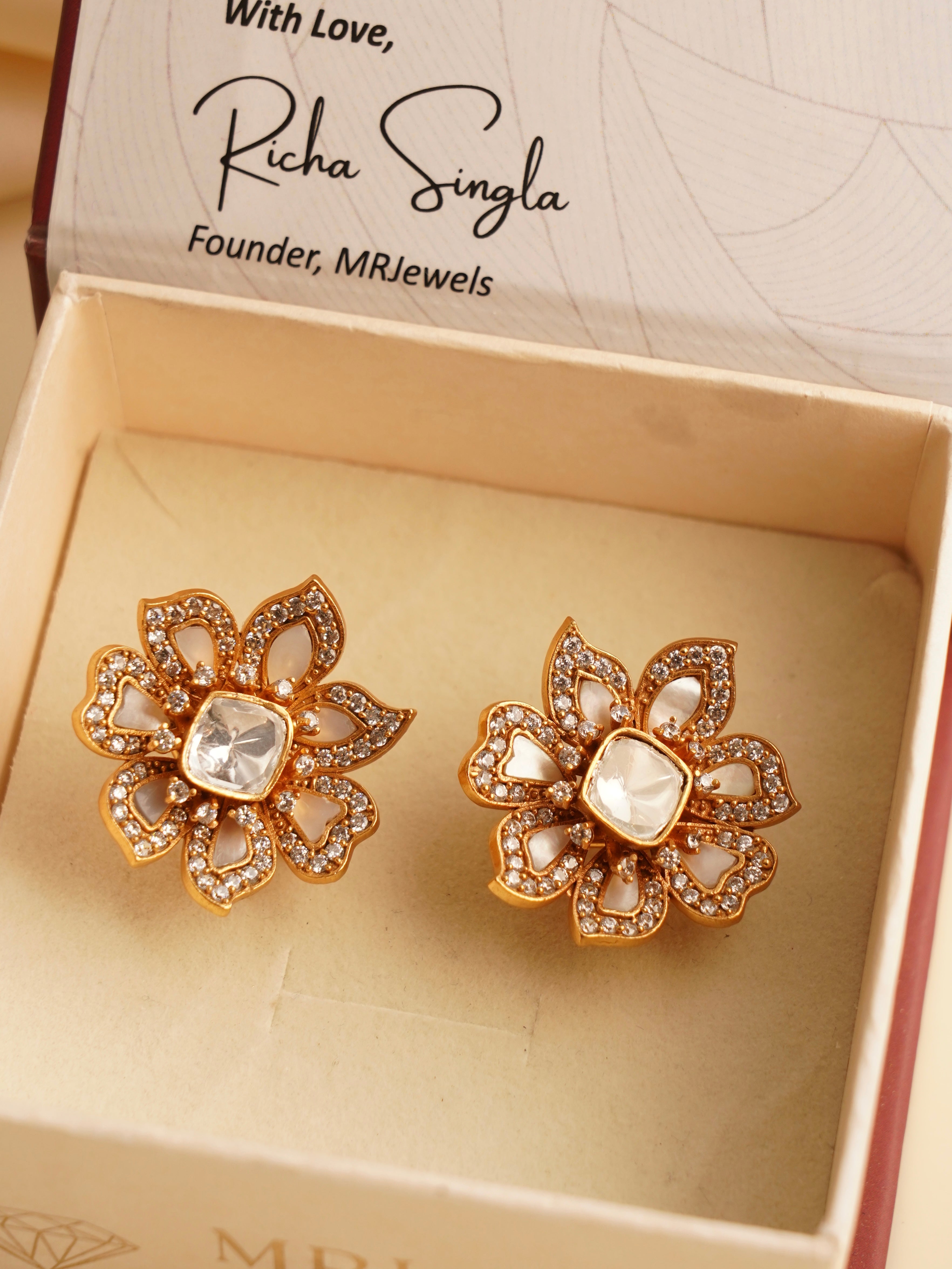 side profile of moissanite and mother-of-pearl stud earrings on display stand