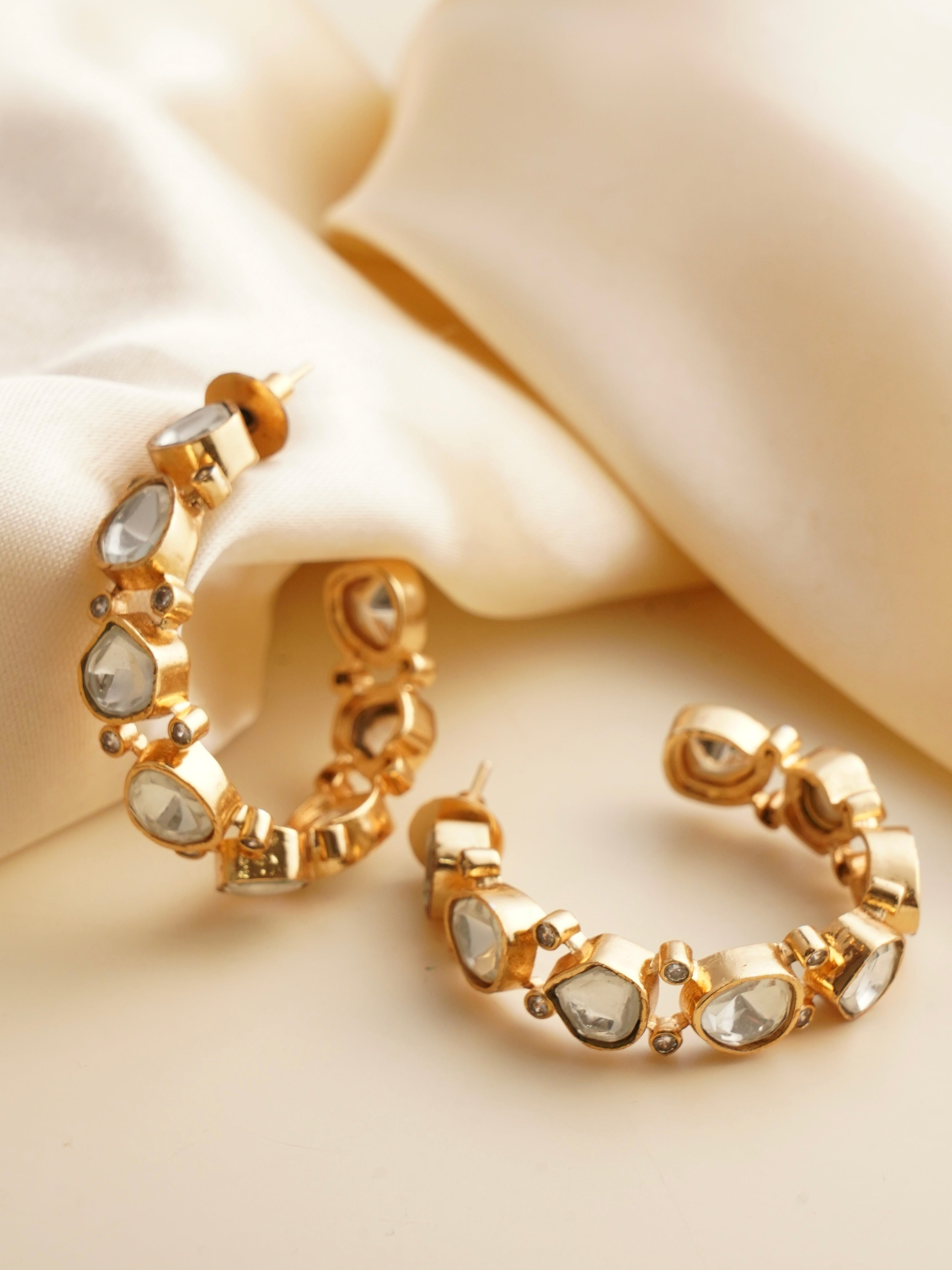 Gold hoop earring with detailed red meenakari and kundan border accents