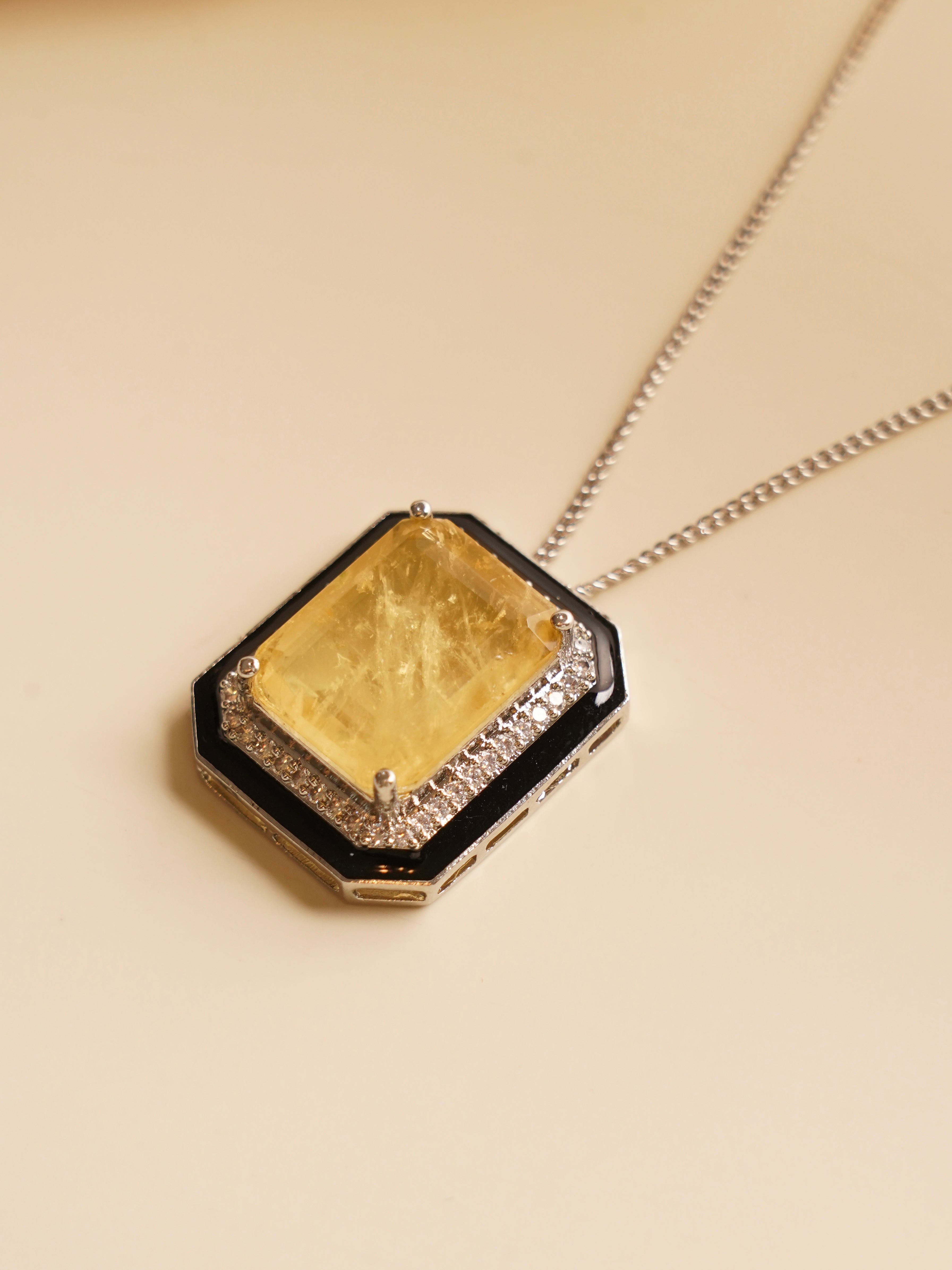 Necklace close-up featuring bold citrine centerpiece and black enamel with detailed zircon surround