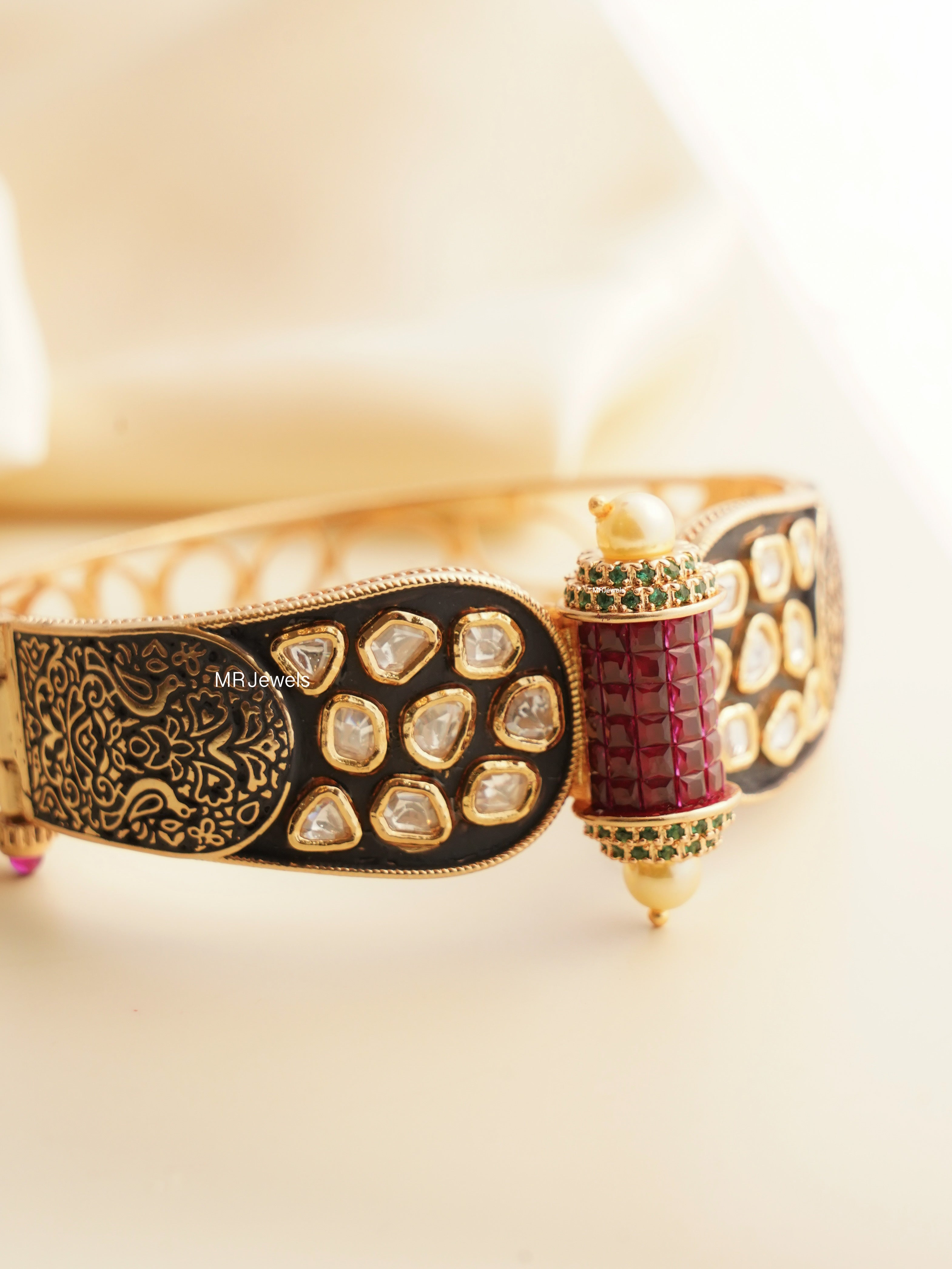 Front view of openable heritage bracelet in gold with ruby and Kundan detailing