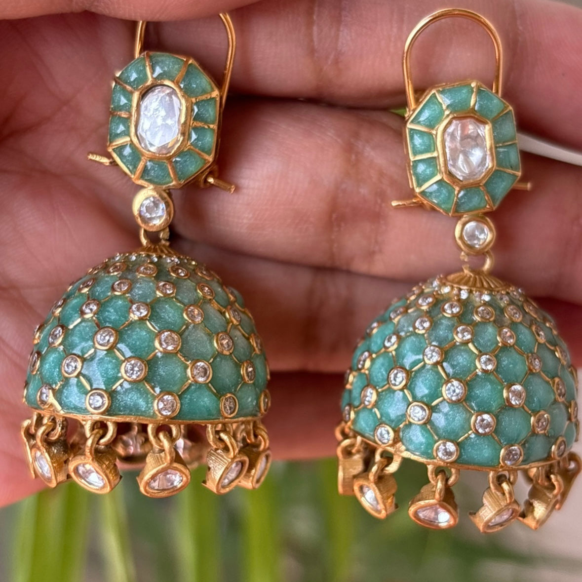 Angled view of jhumkas highlighting polki stones and turquoise enamel finish
