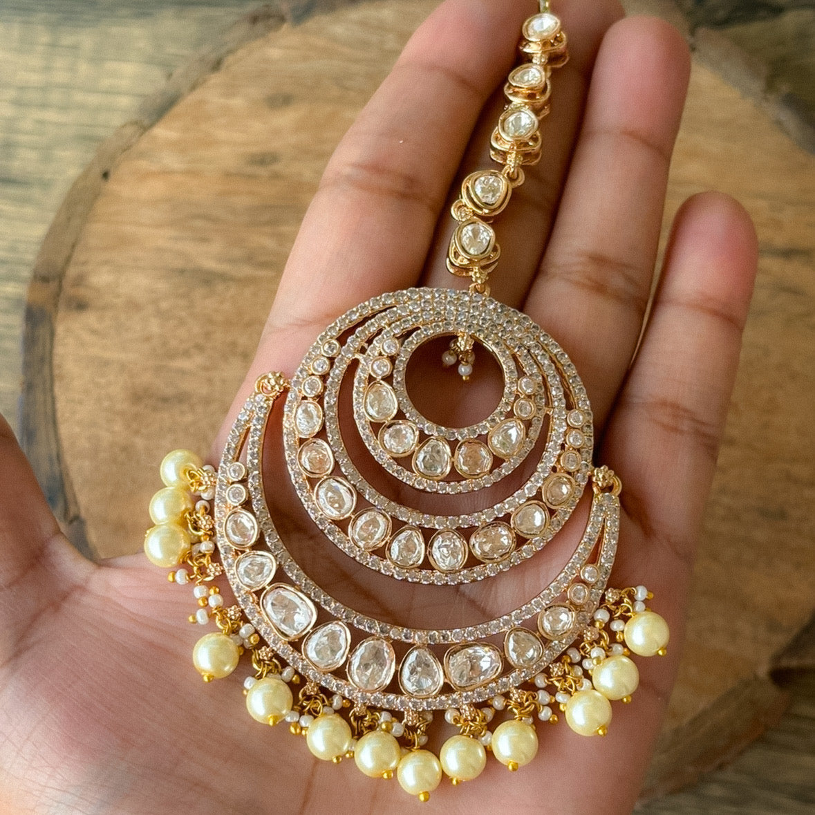 Close-up of crescent-shaped moissanite mangtikka with pearl edging