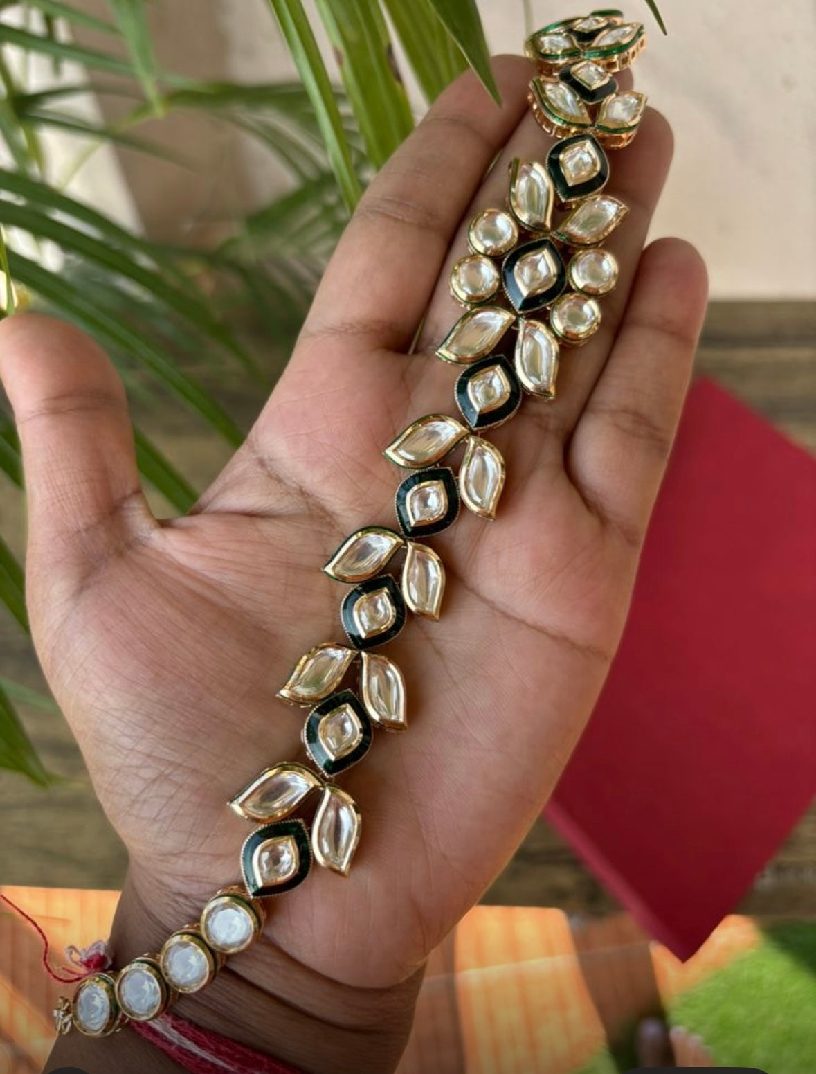 Kundan sheeshphool headpiece with intricate motifs and pearl details, flat lay view