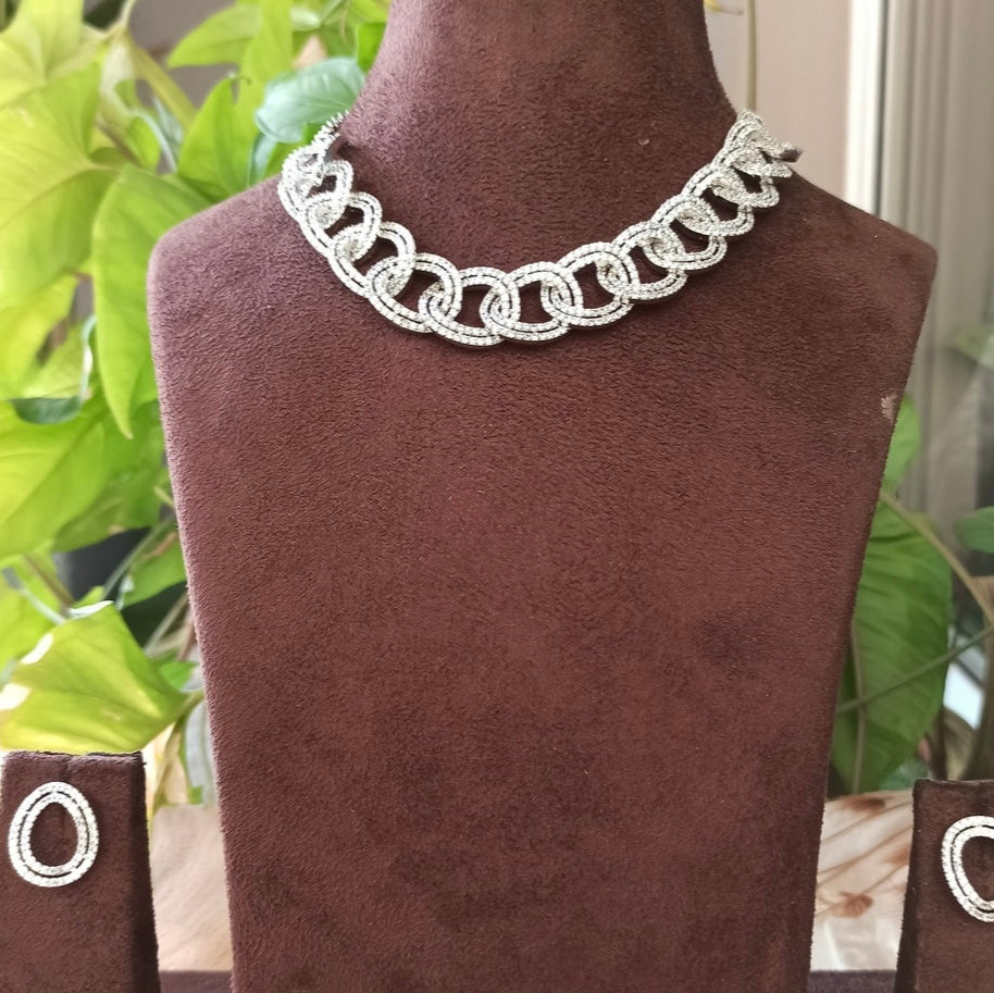 Close-up of Catherine Luxe set with gem-studded necklace and round drop earrings