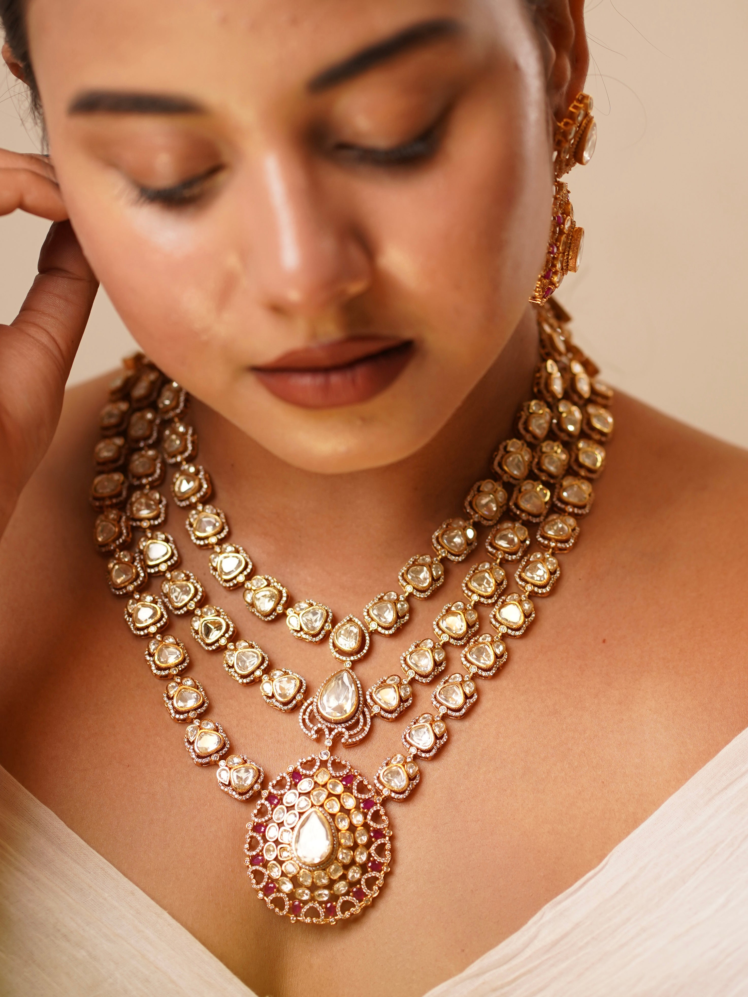 Moissanite bridal layered necklace set featuring three rows of moissanite stones and a pear pendant with ruby accents