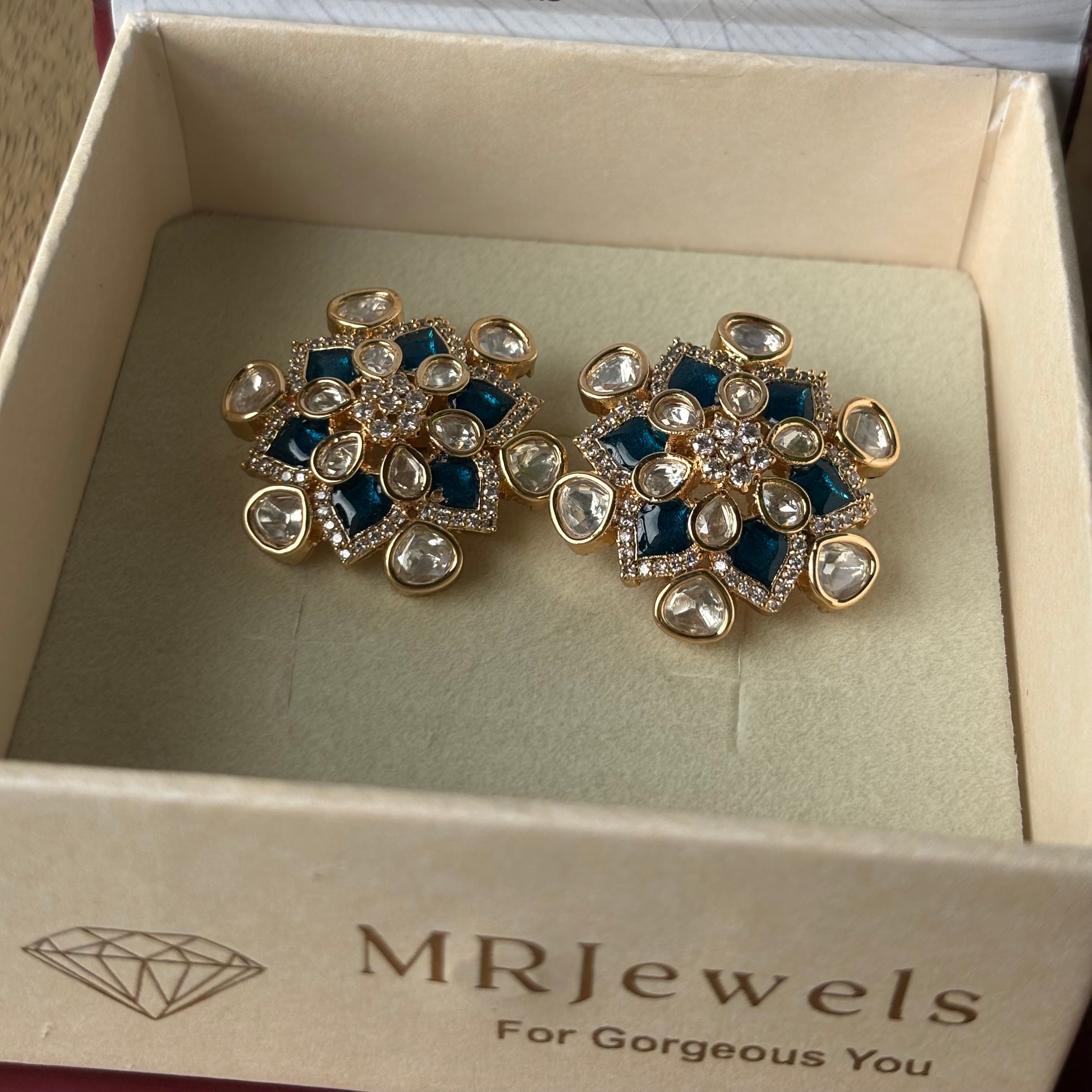 Close-up of blue enamel floral earrings with intricate kundan craftsmanship