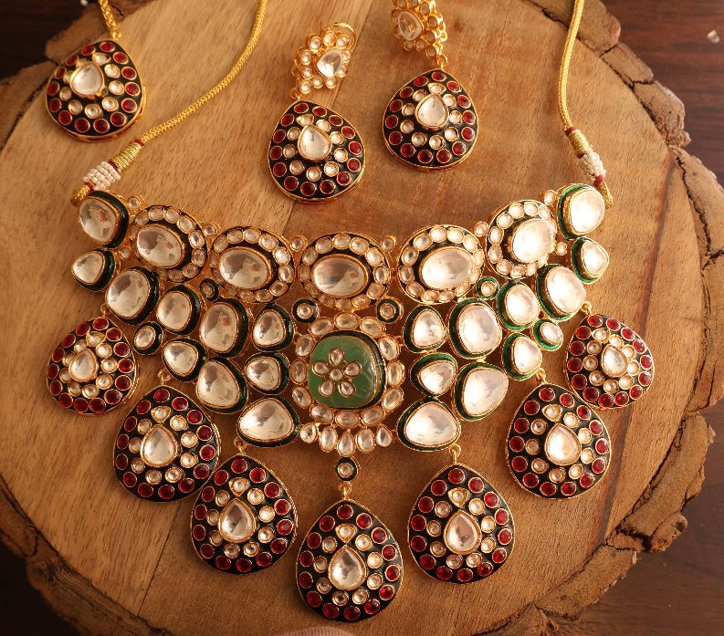 Angled view of full necklace set with earrings and maangtikaa in traditional ruby polki design