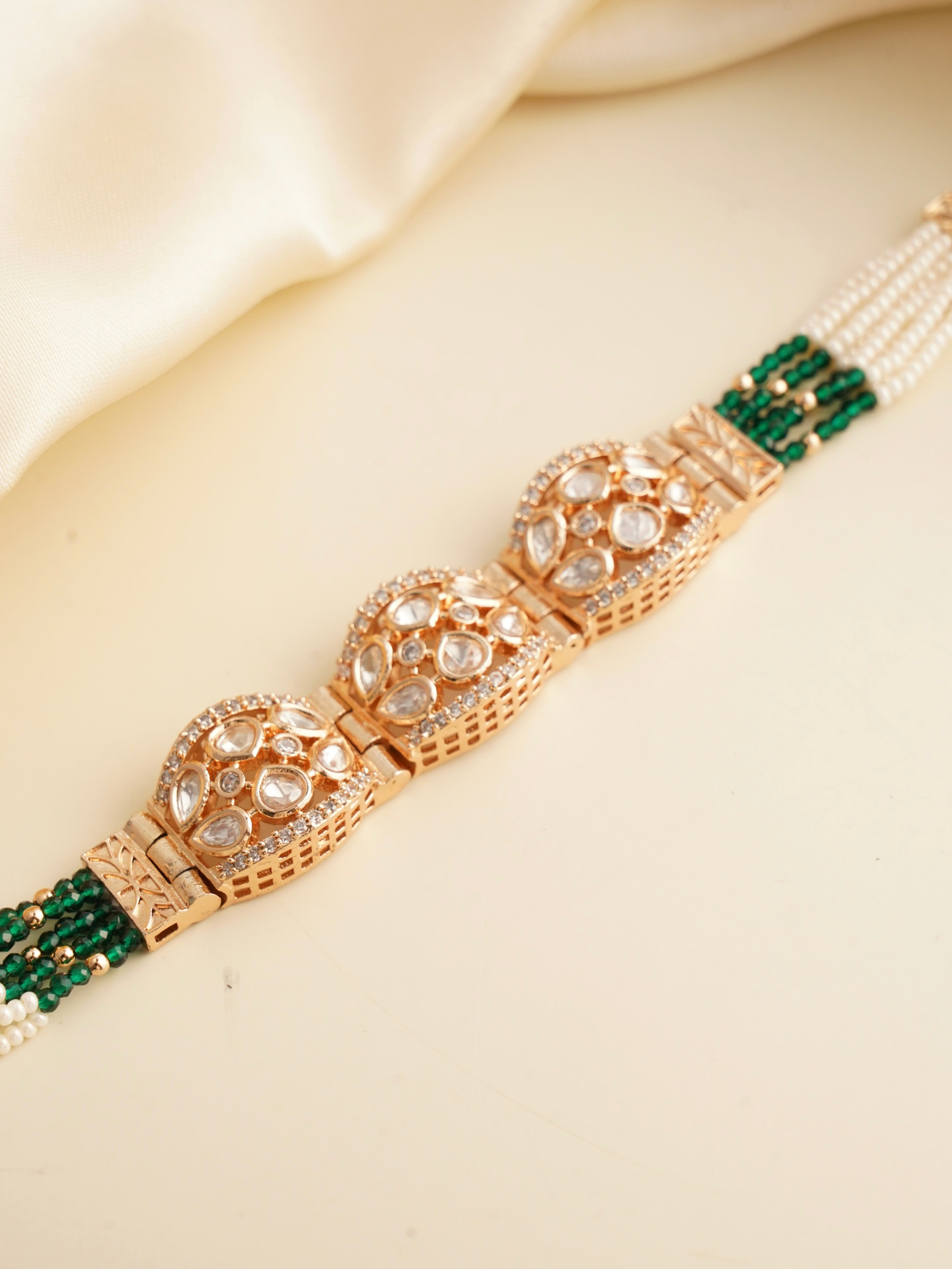 Polki dome bracelet with uncut stones, pearl strands and emerald green bead detailing