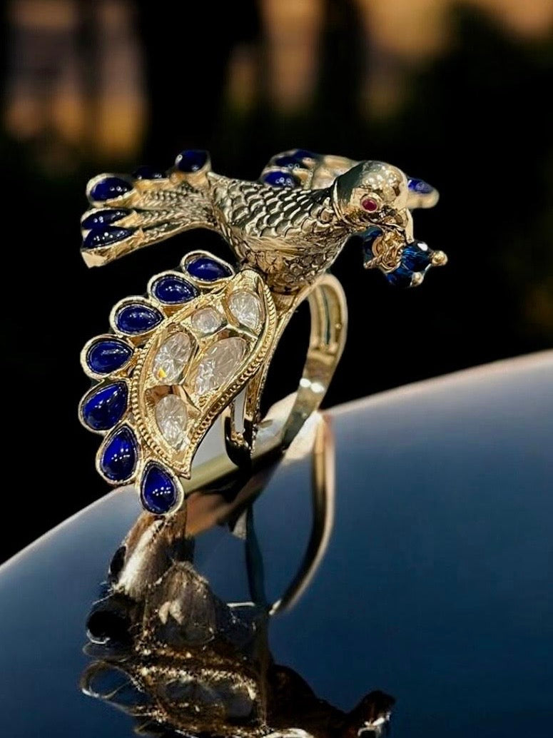 Side view of bird motif ring with emerald enamel and hand-set kundan stones on gold finish