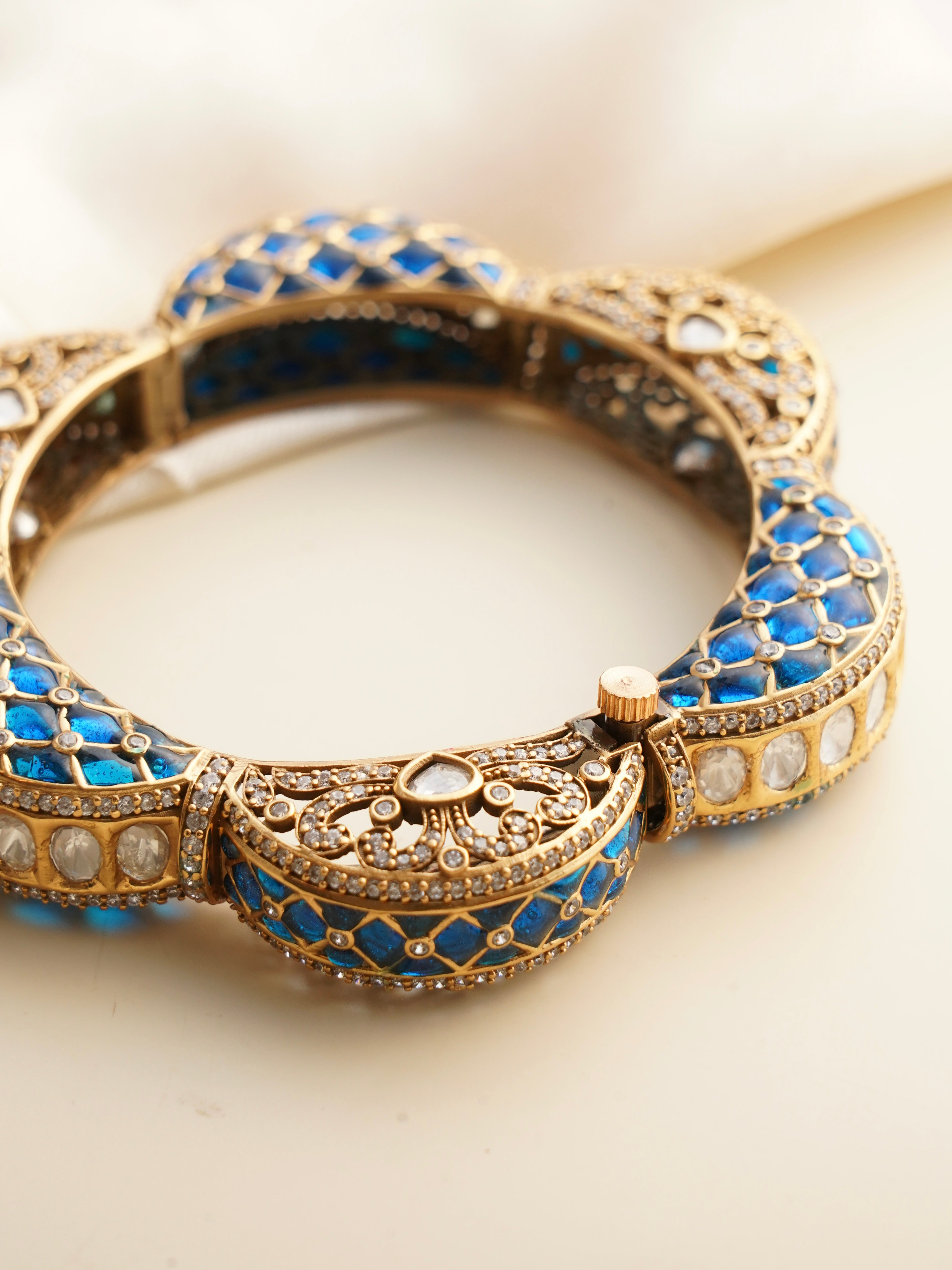 Artistic kada bangle with intricate polki and vibrant gemstone accents in gold finish