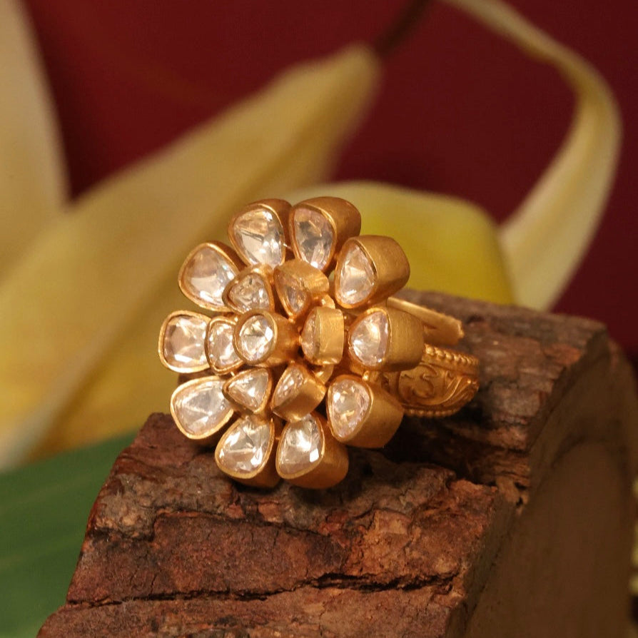 Side angle of moissanite flower ring with shimmering gold plating and petal detailing