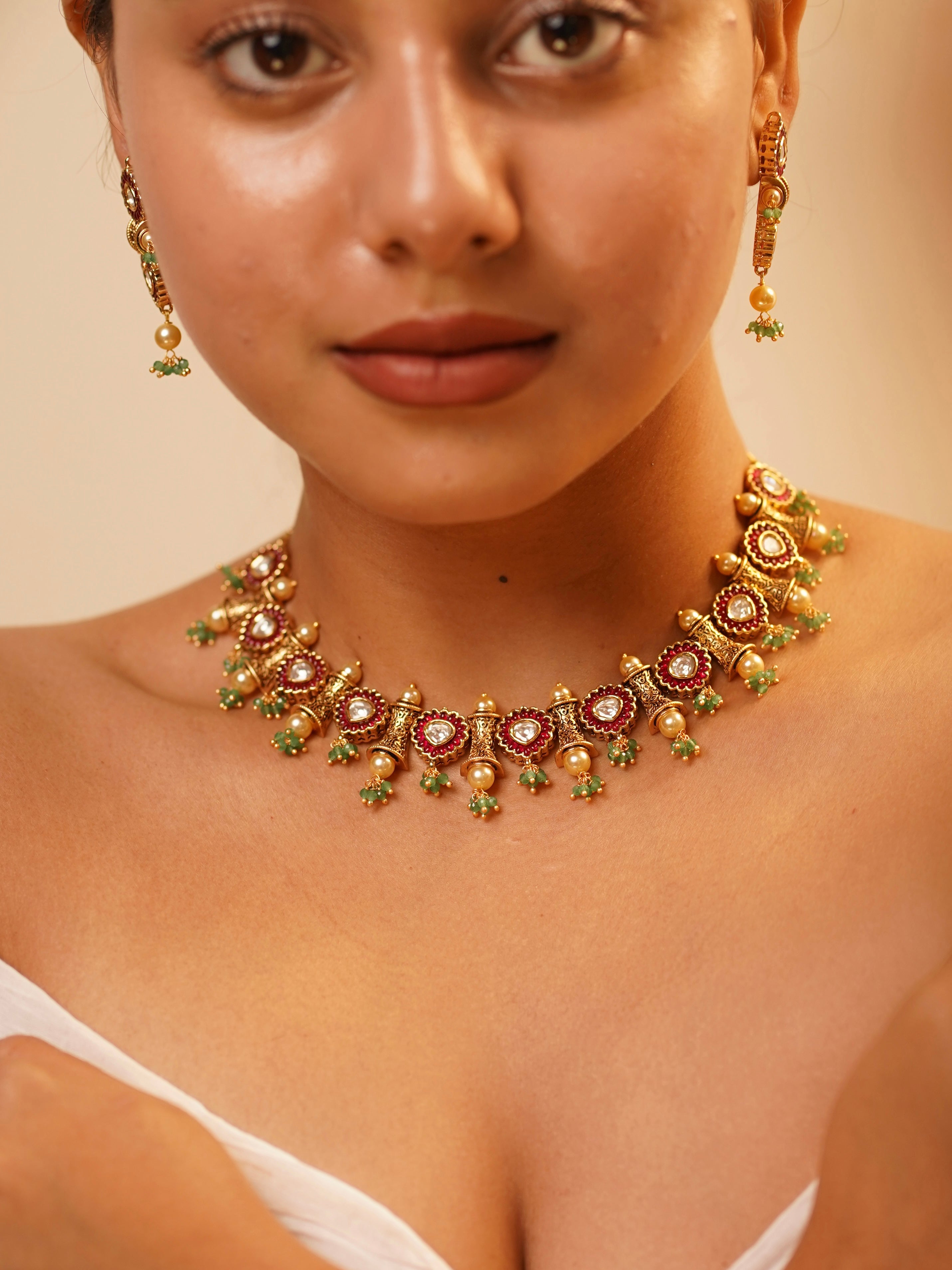 Vilandi kundan necklace set with red enamel accents and green bead drops