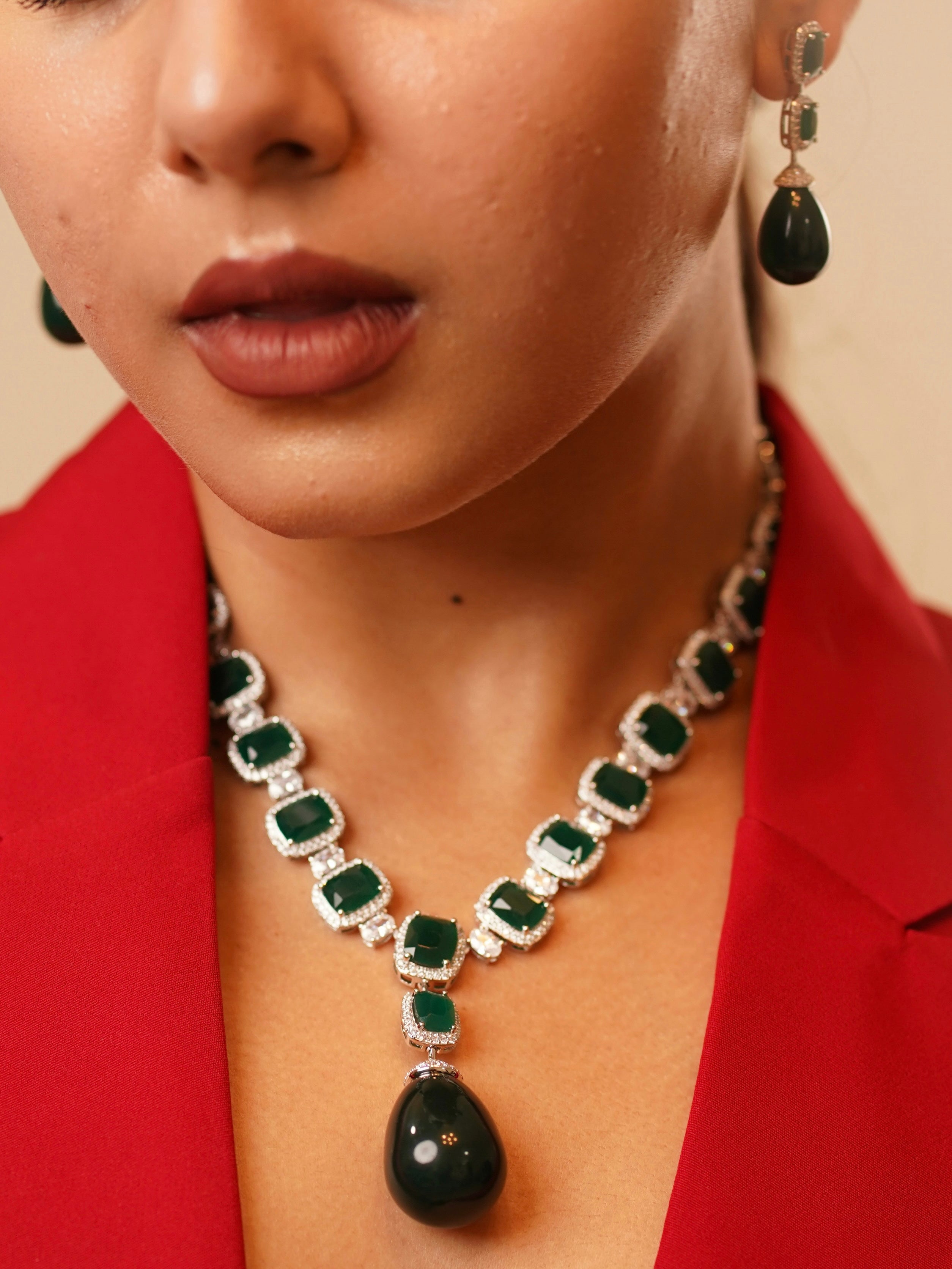 Close-up of empress emerald necklace and earrings showing faceted emeralds with pavé crystal accents