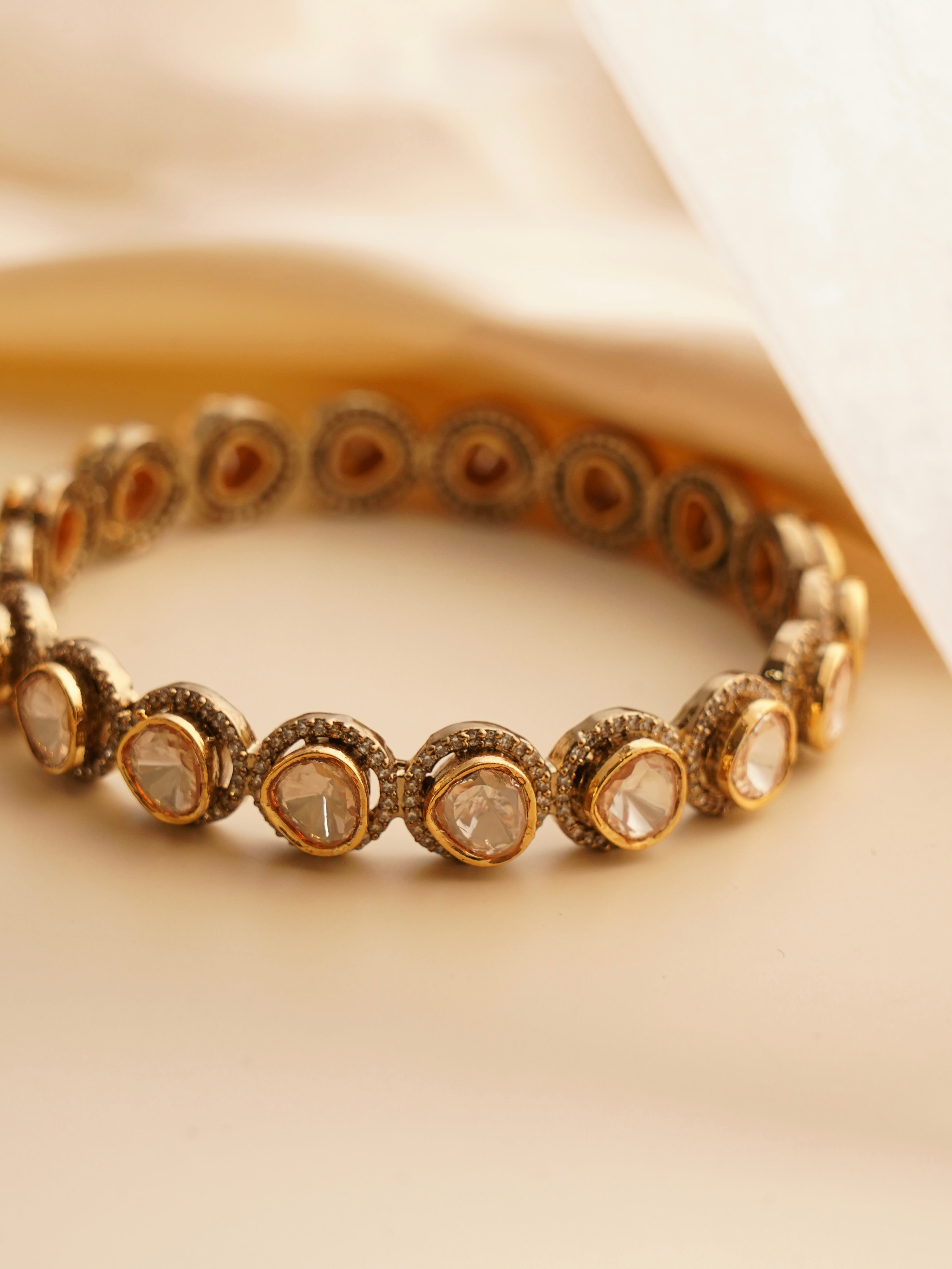 Front view of gold moissanite bangle with shimmering texture and polished outer layer