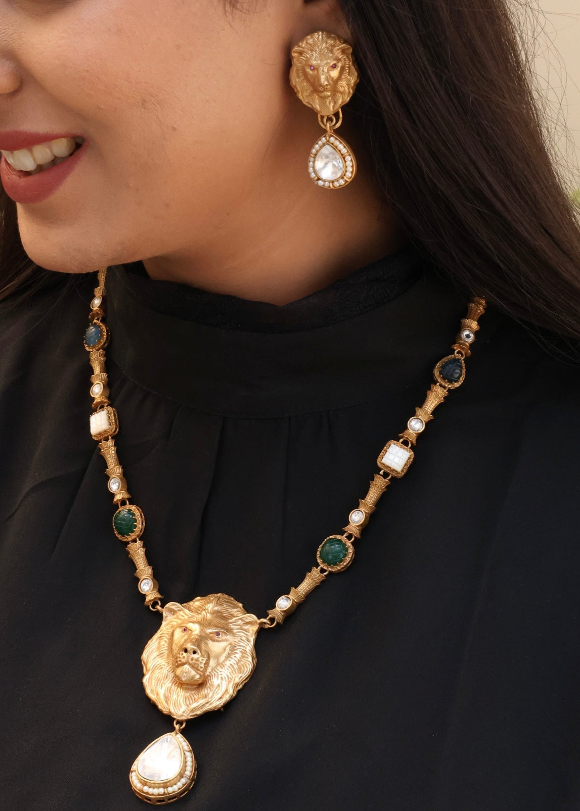 Angled view of lion motif necklace showcasing regal pendant and matching earrings