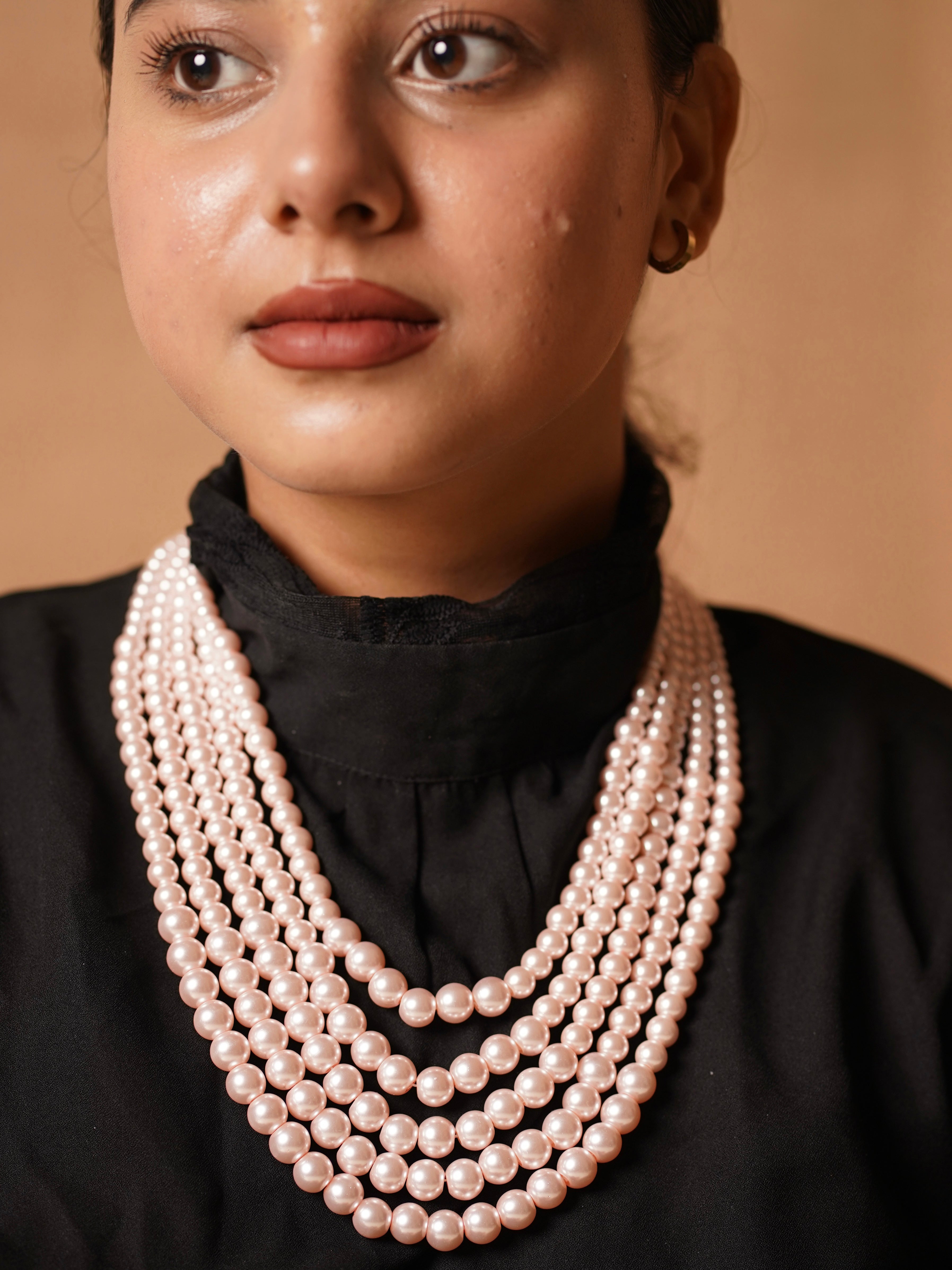 Close-up of layered pearl necklace with floral-inspired clasp finish