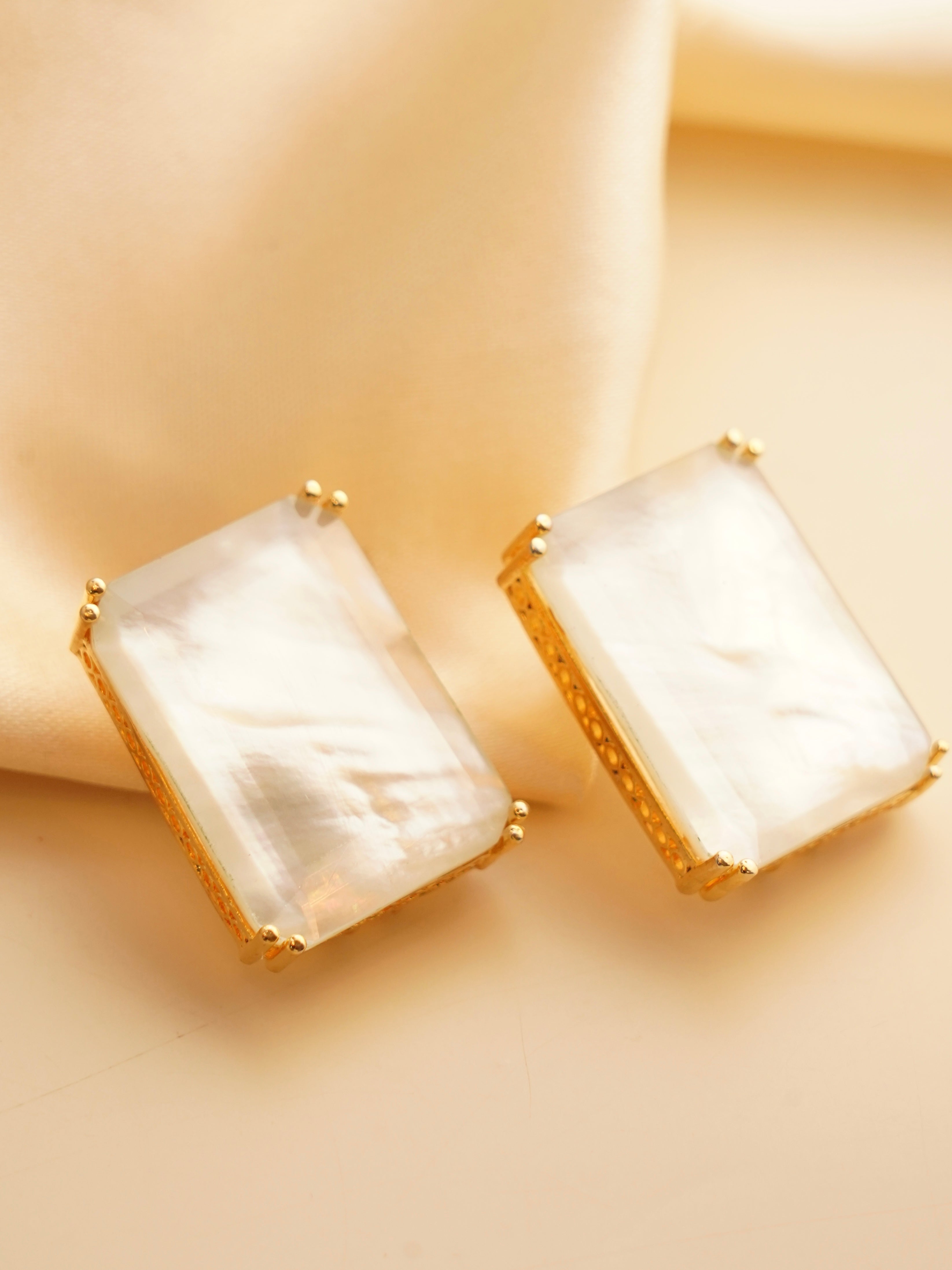 Side view of rectangular gemstone earrings with modern gold framing