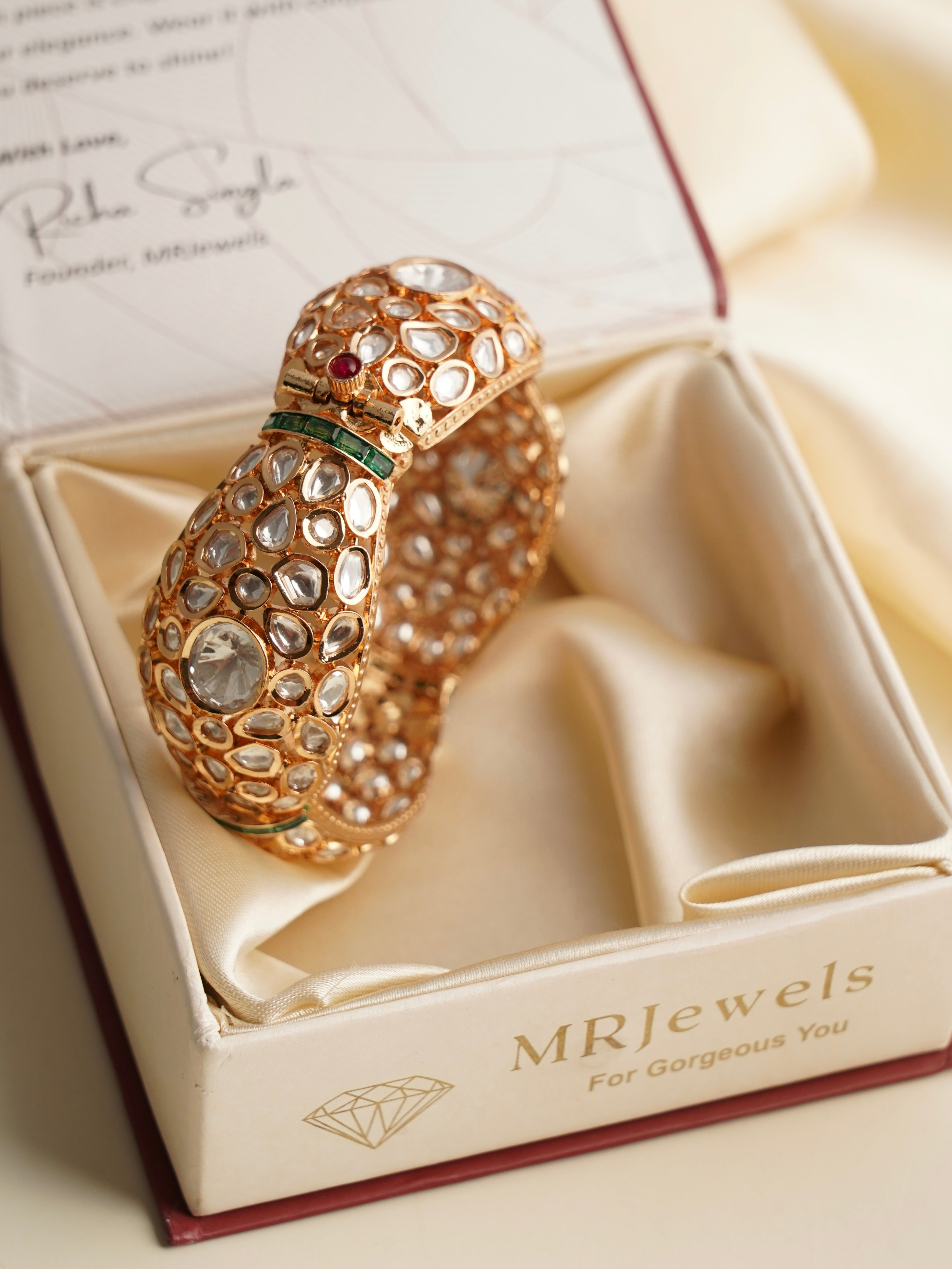 Side view of intricate polki kada with shimmering kundan detailing on golden base