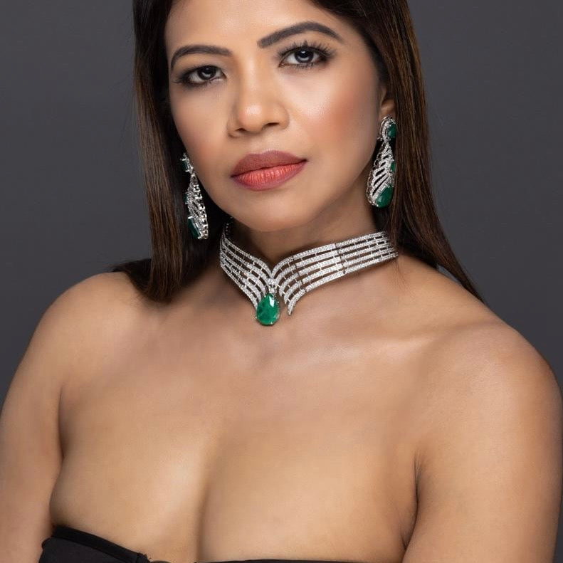 Designer emerald jewellery set with vivid stones in flowing layout, front-facing display