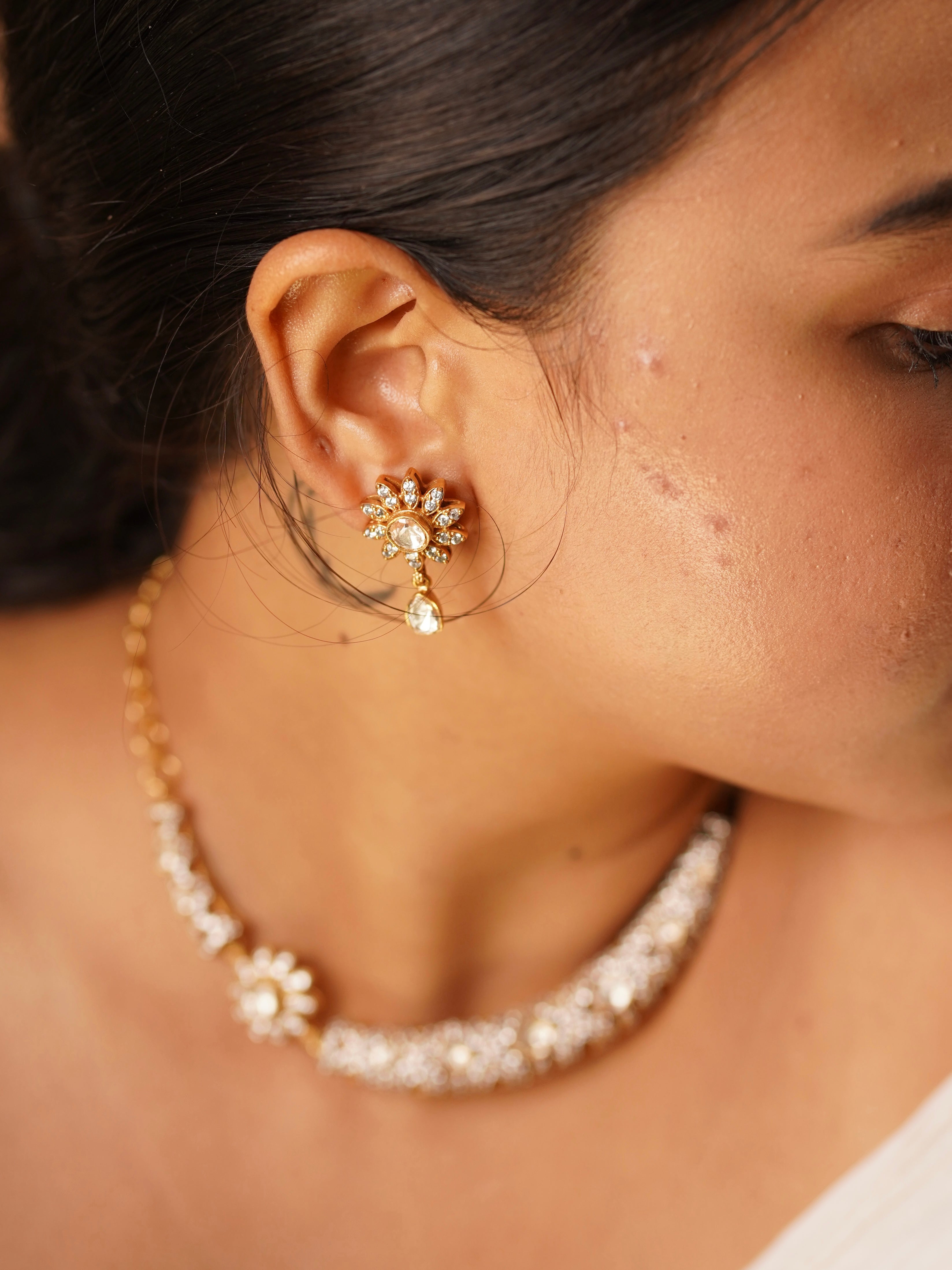 Close-up of Aarohi floral kundan earring featuring petal motif, hanging stone and coordinating necklace