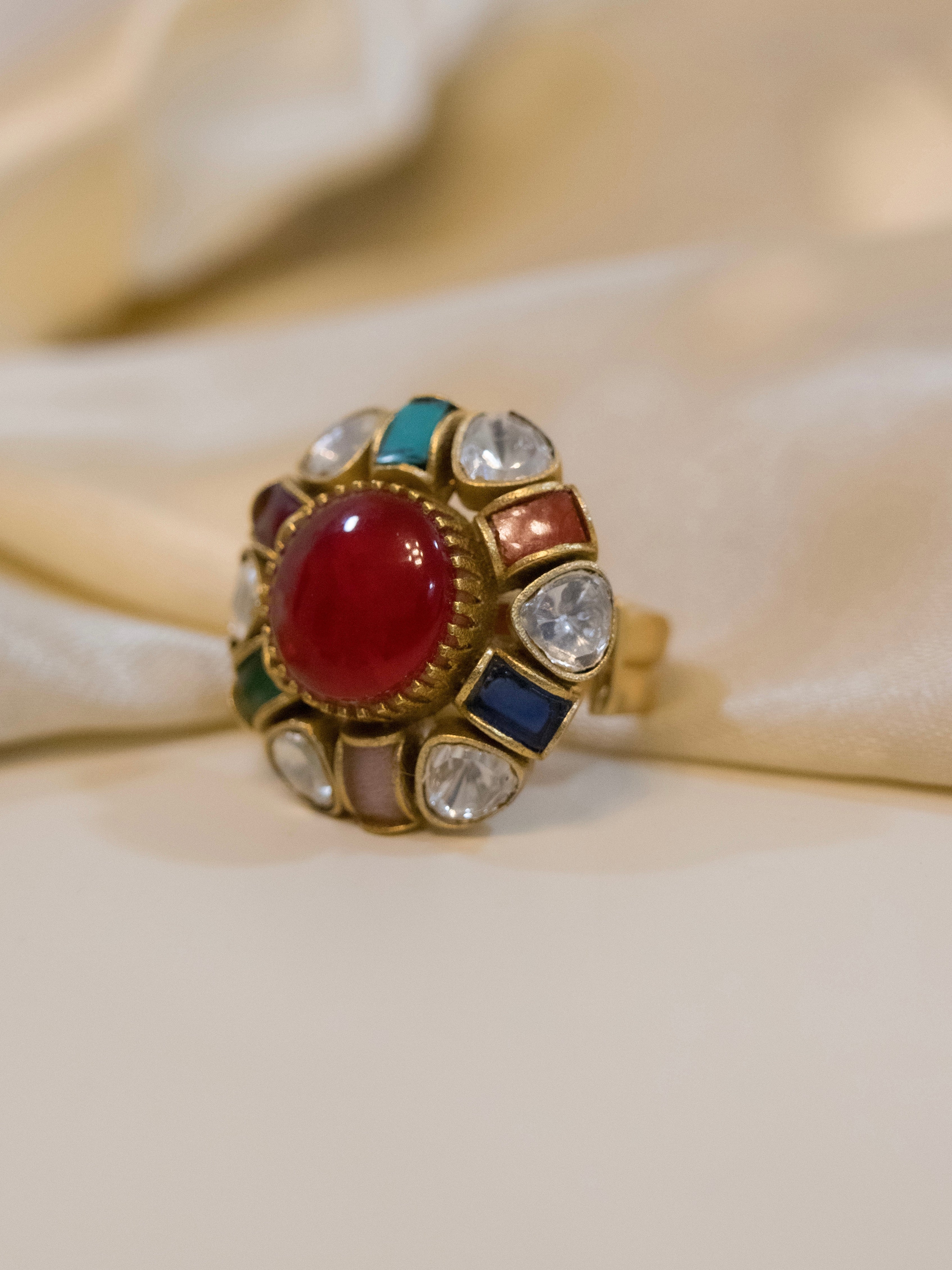 Navratna statement ring with red cabochon centre and surrounding nine gemstones