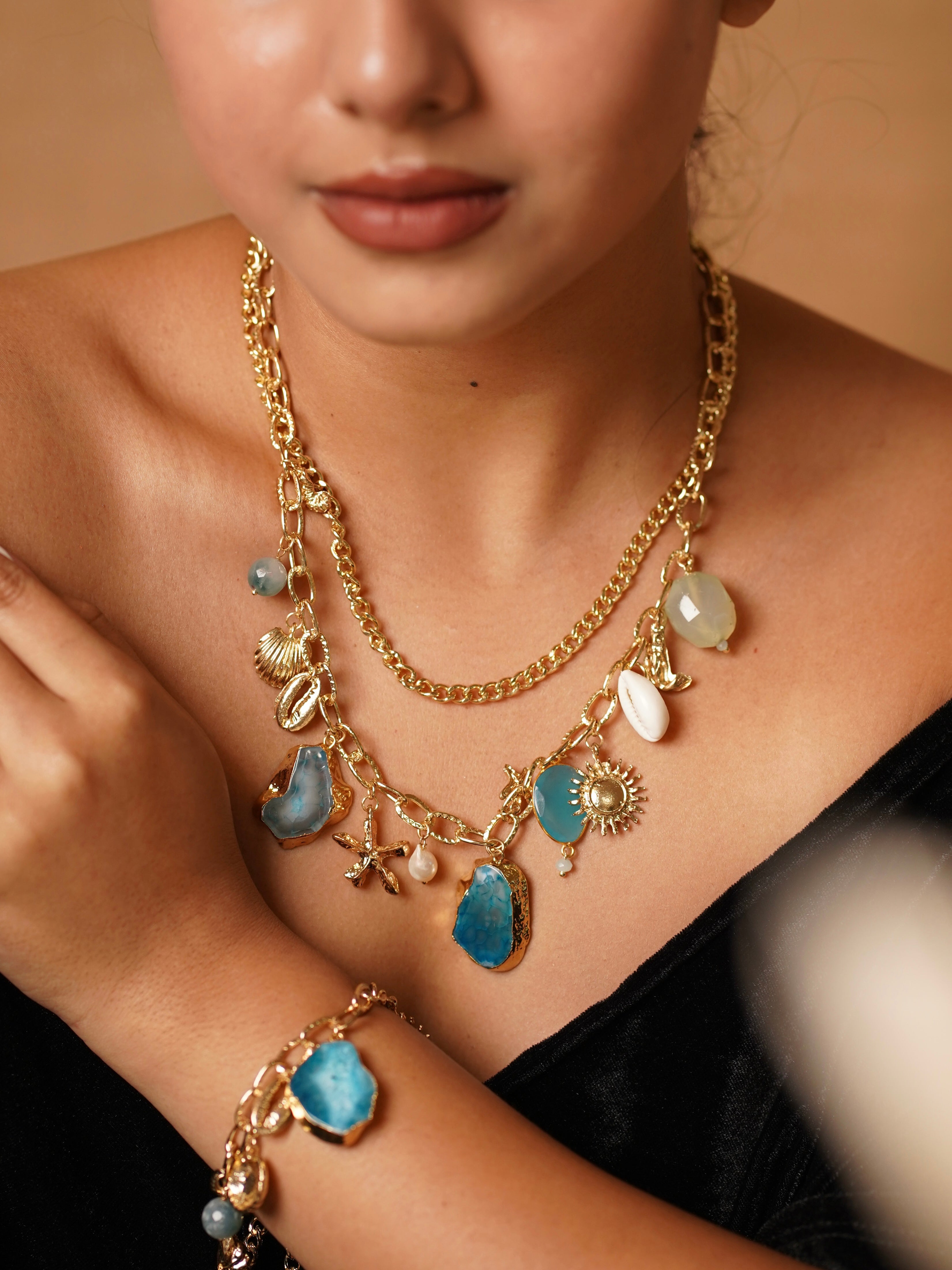 Close-up of azure charm set showing enamel drops and shell-inspired shapes