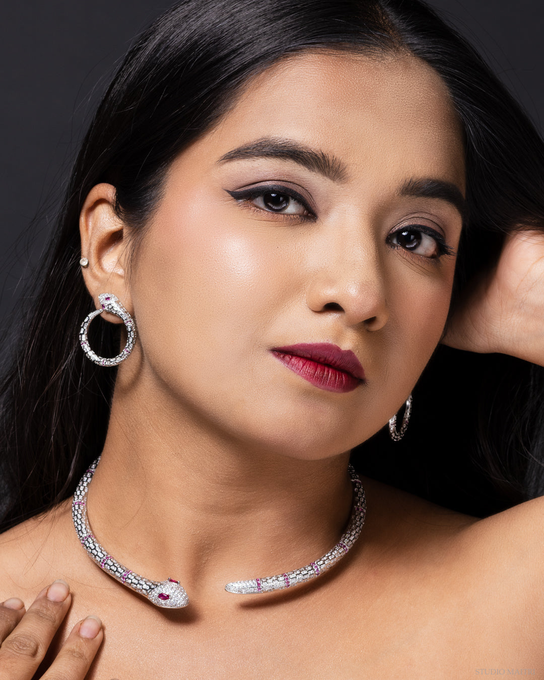 Serpent-shaped necklace with crystal embellishments and ruby-toned eyes in luxe finish