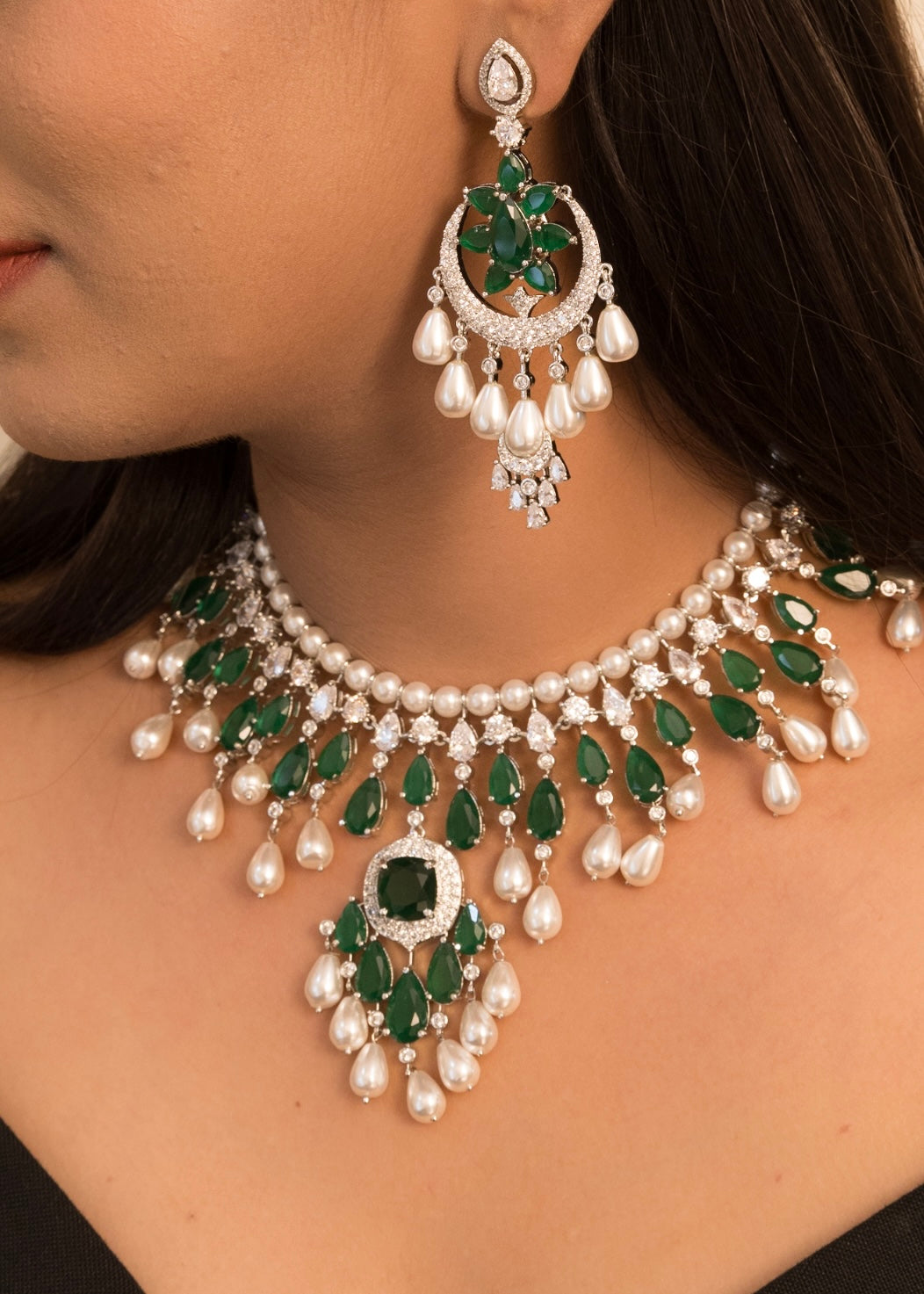Angled shot of Radhika Merchant–inspired necklace highlighting pearl drops and green stones