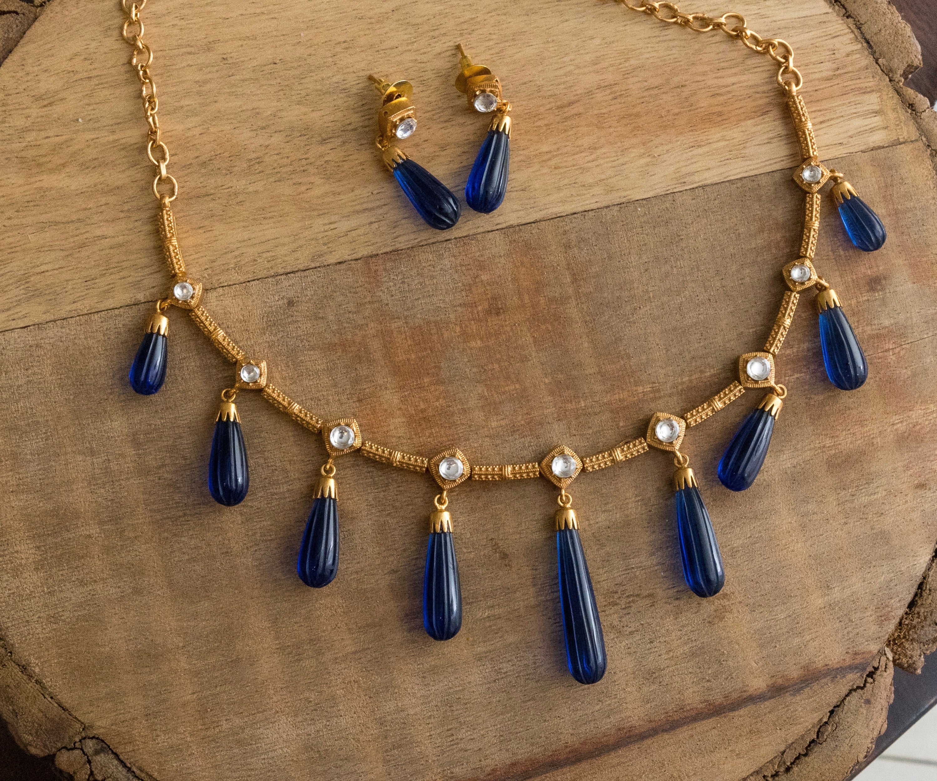 Side perspective of necklace and earrings with beaded embellishments and gold accents