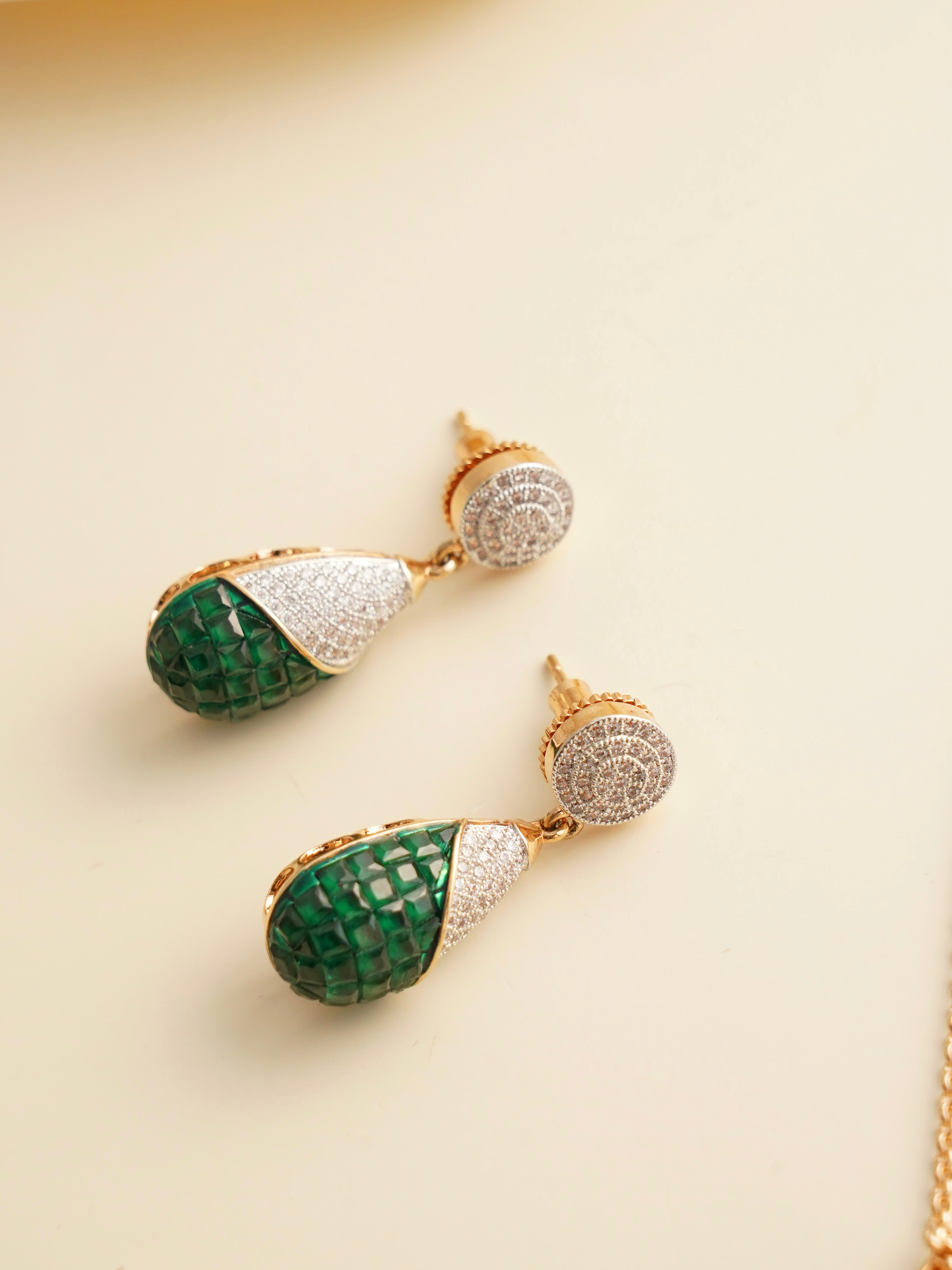 Side view of emerald drop earrings showing mosaic inlay and micron gold finish