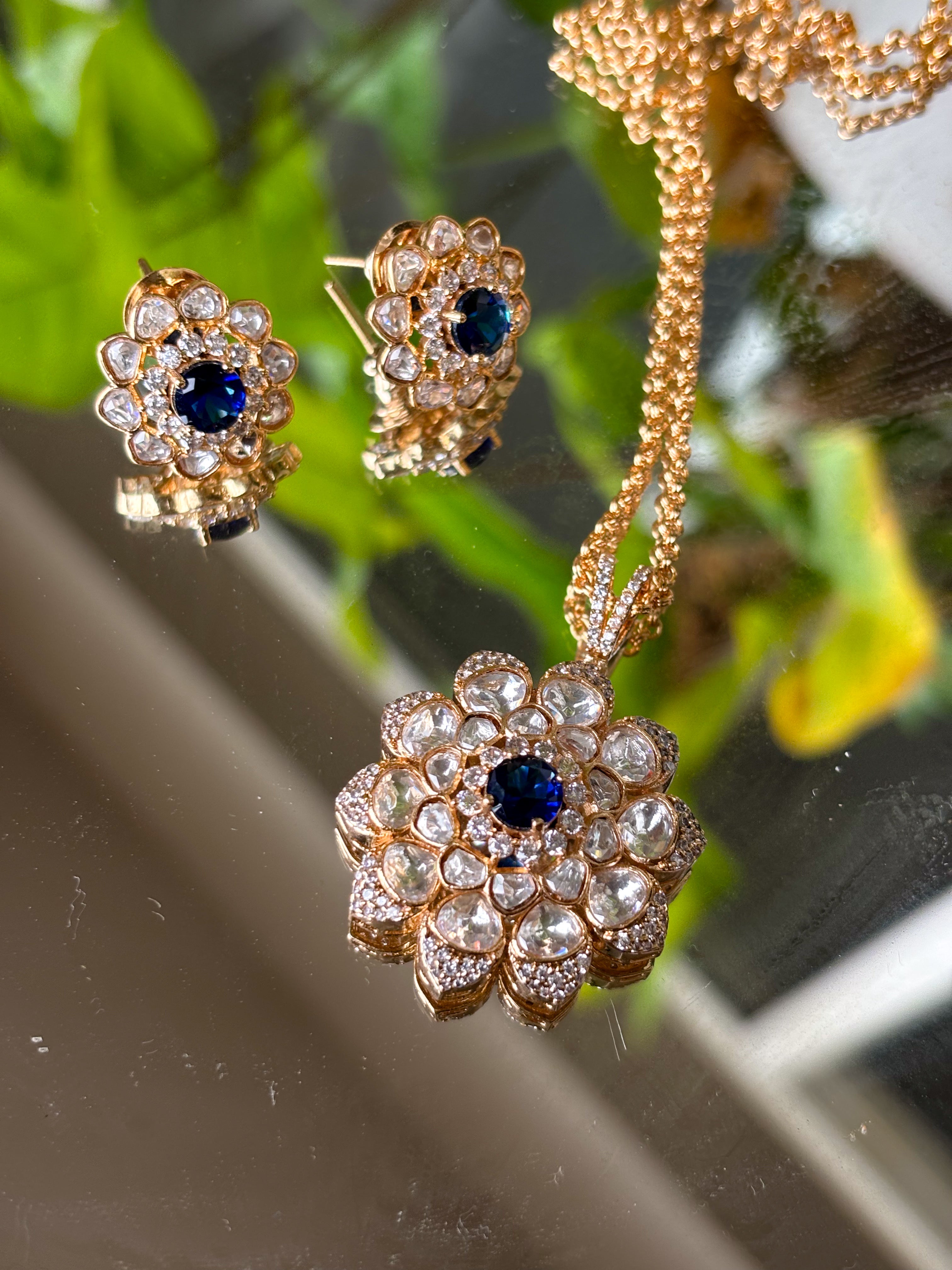 Front view of floral kundan pendant set with matching round earrings