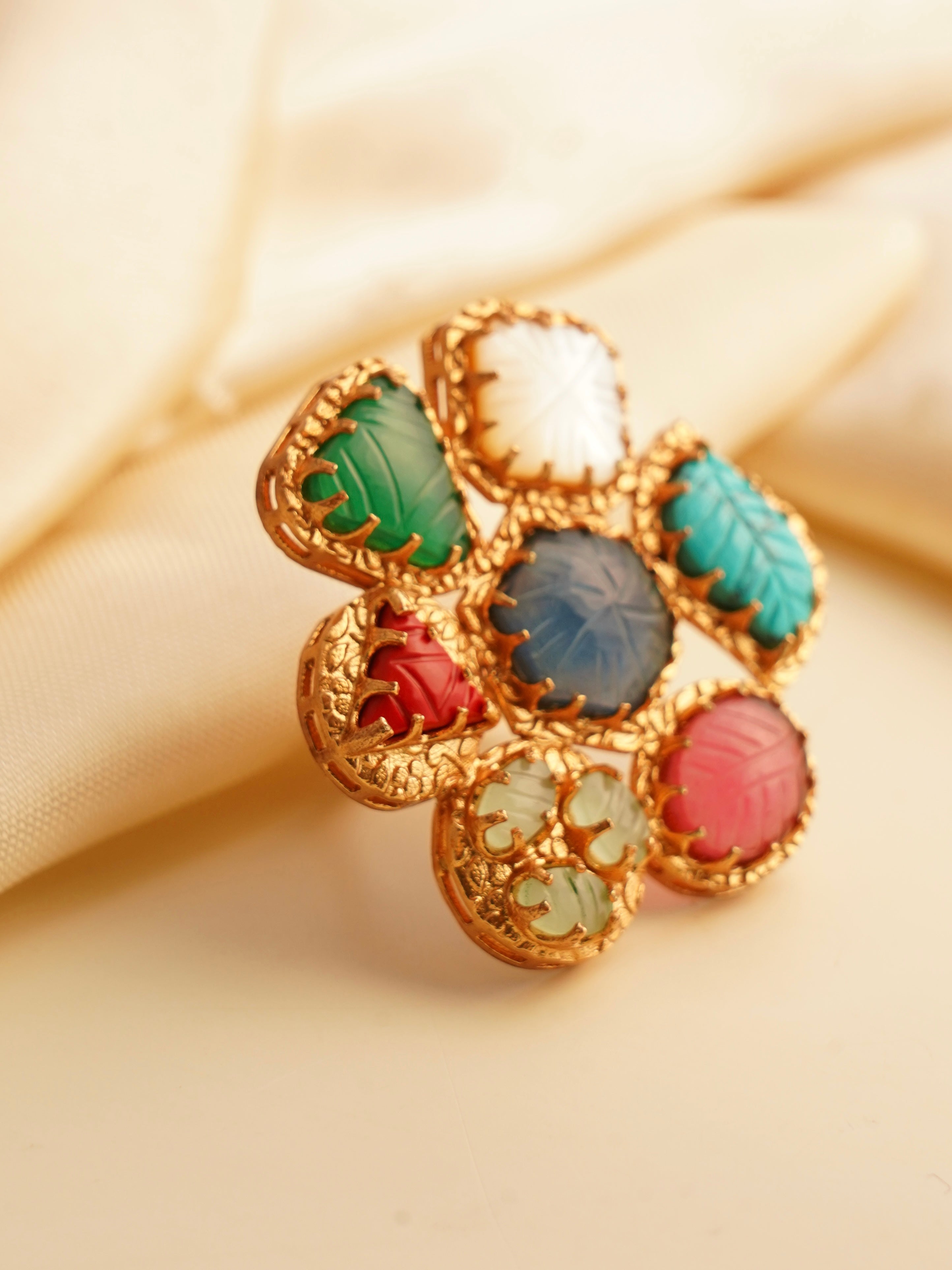 Navratna ring with red cabochon centre and multicoloured gemstone bezel