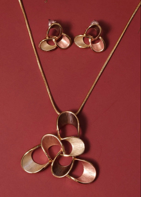 Close-up of trendy pendant set featuring sleek finish and matching stud earrings