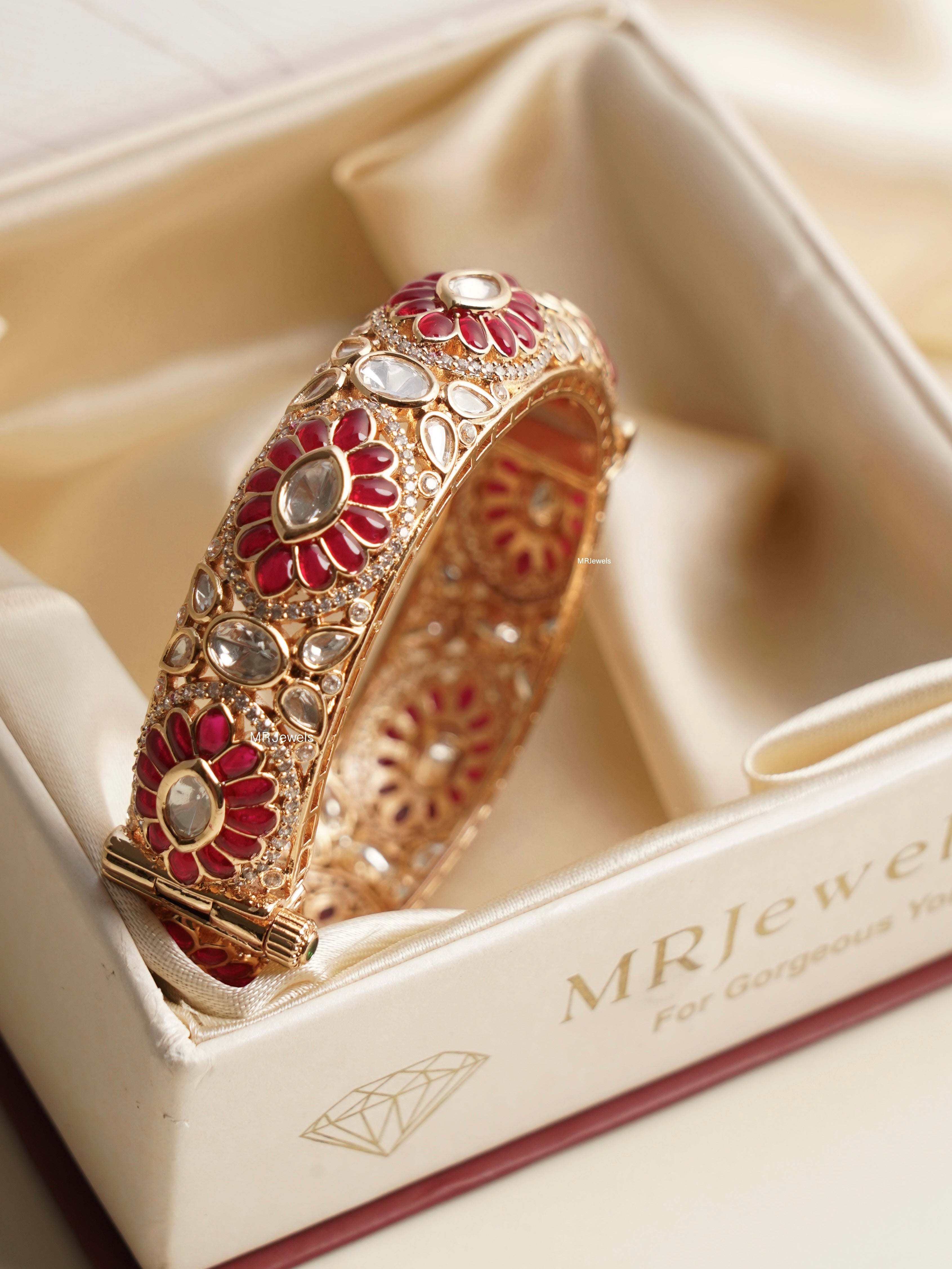 Angled view of openable kada with ruby polki and moissanite embellishments