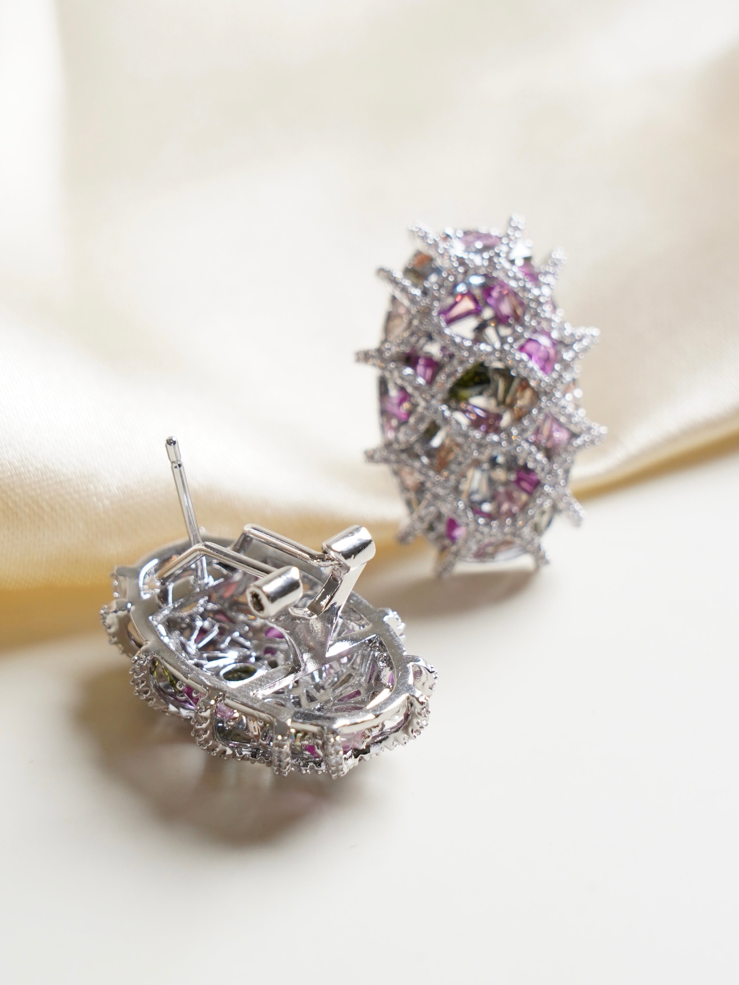 Angled view of swarovski crystal studs showcasing multicolour shimmer in oval rhodium design