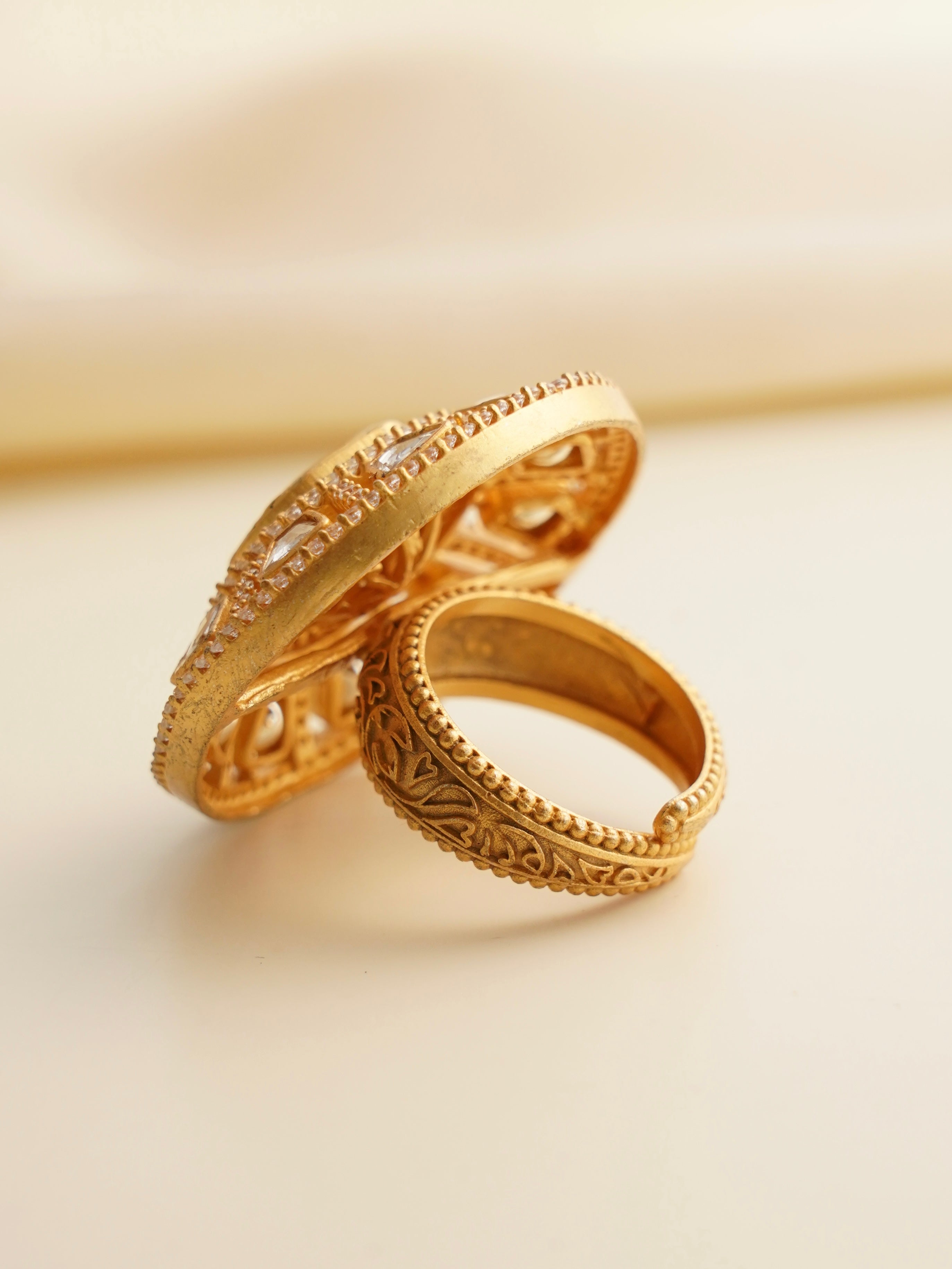 Close-up of moissanite solitaire ring with double band detail in gold-tone finish