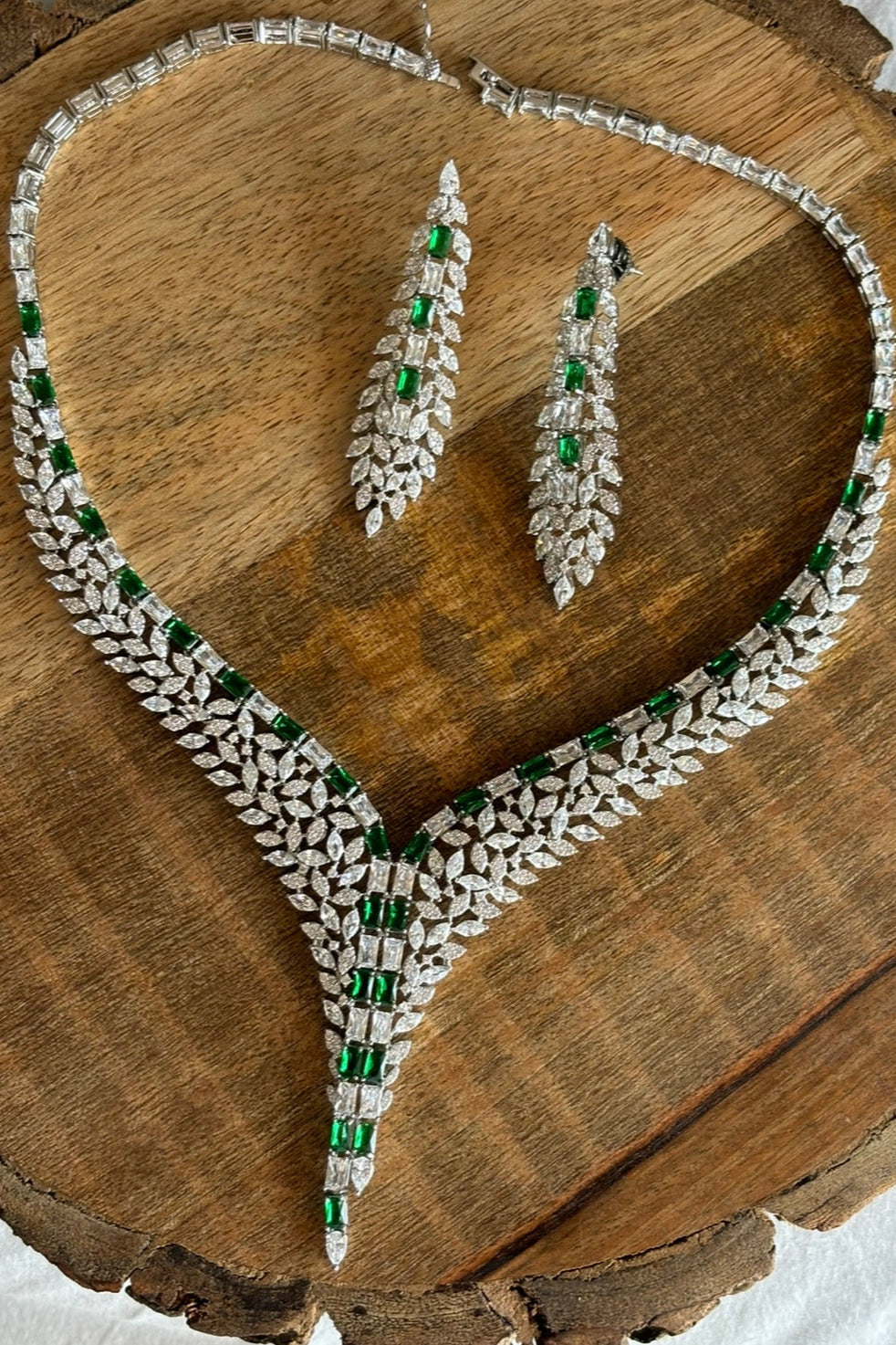 Angled view of Royal Ivy necklace showcasing brilliant-cut diamonds and green emeralds