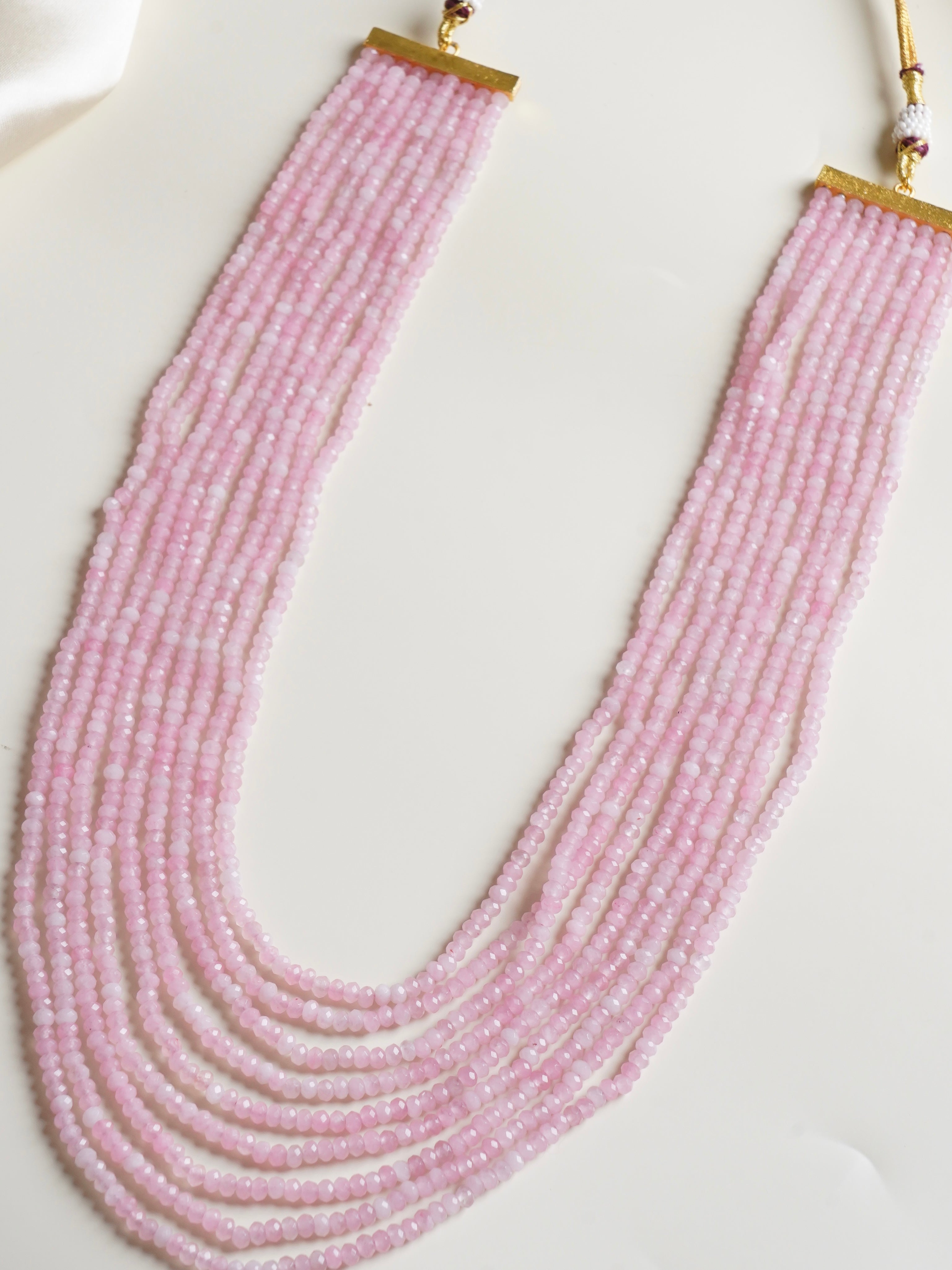 Top view of colorful faceted gemstone necklace arranged in radiant overlapping strands